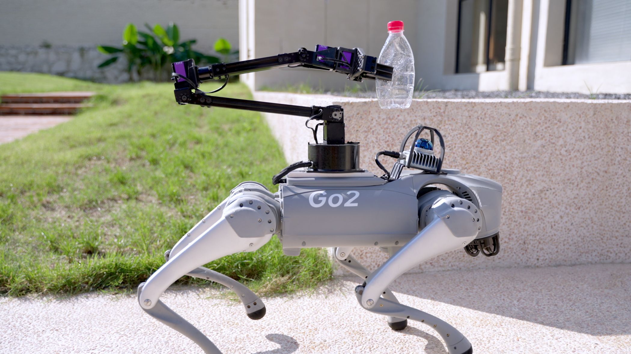 The Unitree Go2 Using The Robotic Arm Attachment to Carry a Discarded Water Bottle