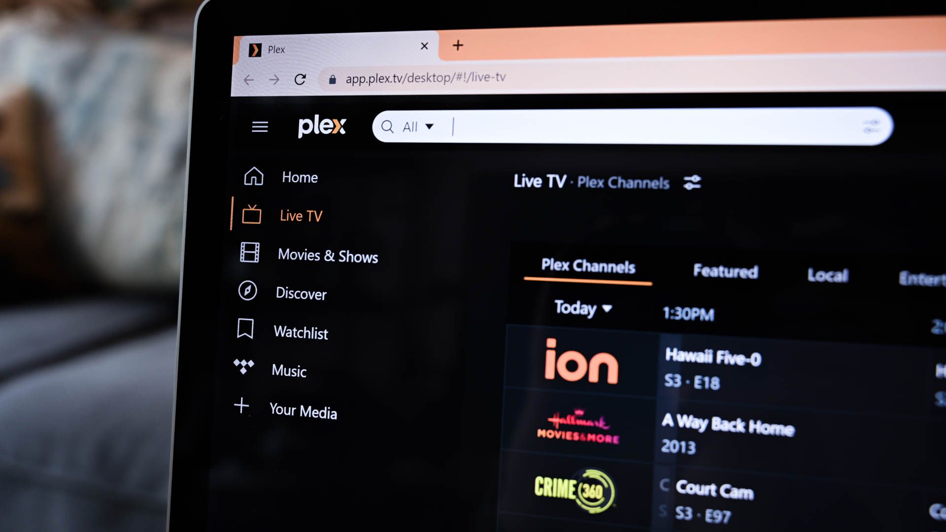 Plex web app opened on a laptop with the search bar visible and live tv tab highlighted.