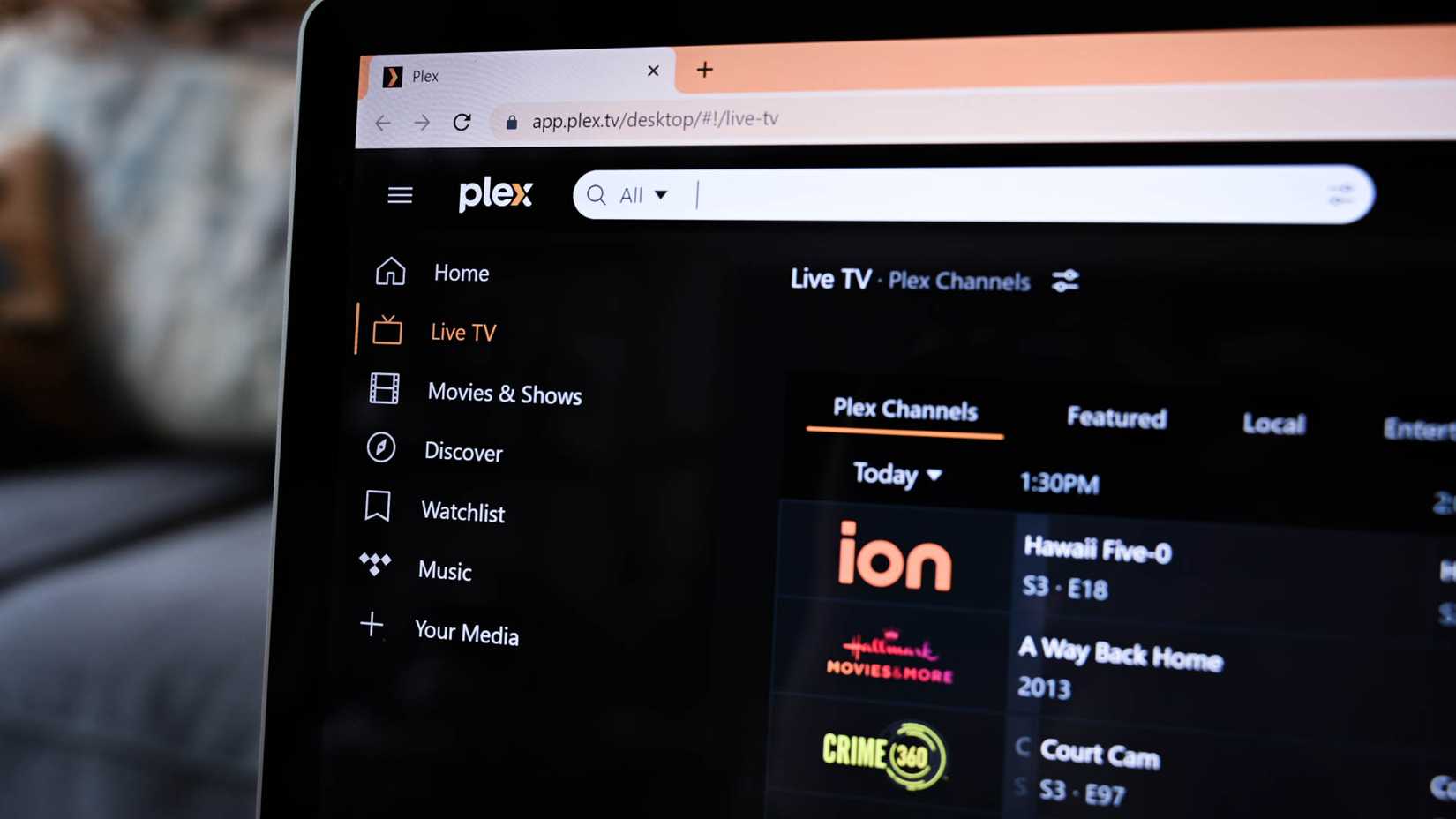 The plex web application open to a laptop with the visible search bar and the live TV tab highlighted.