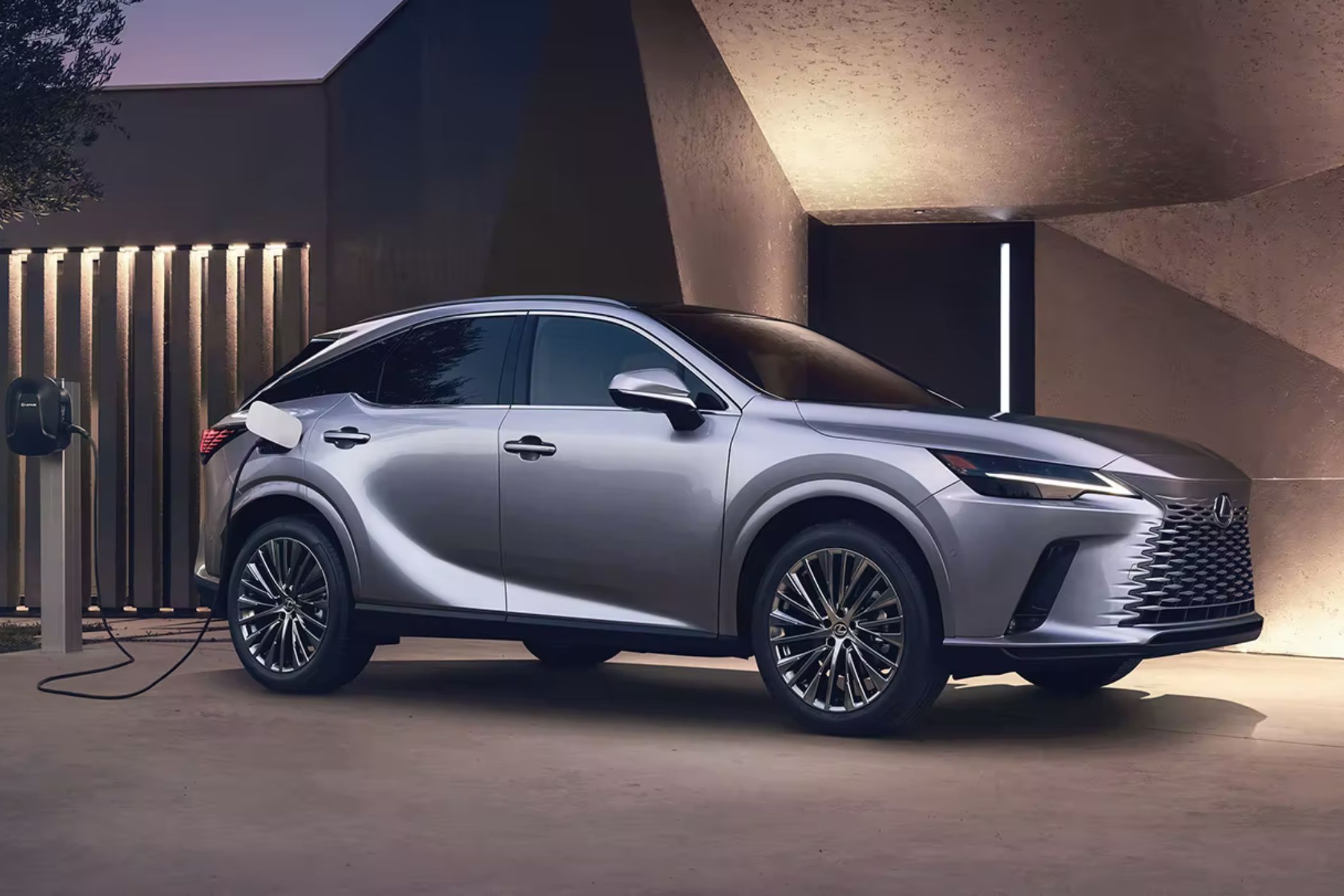Lexus RX PHEV charging in a driveway.