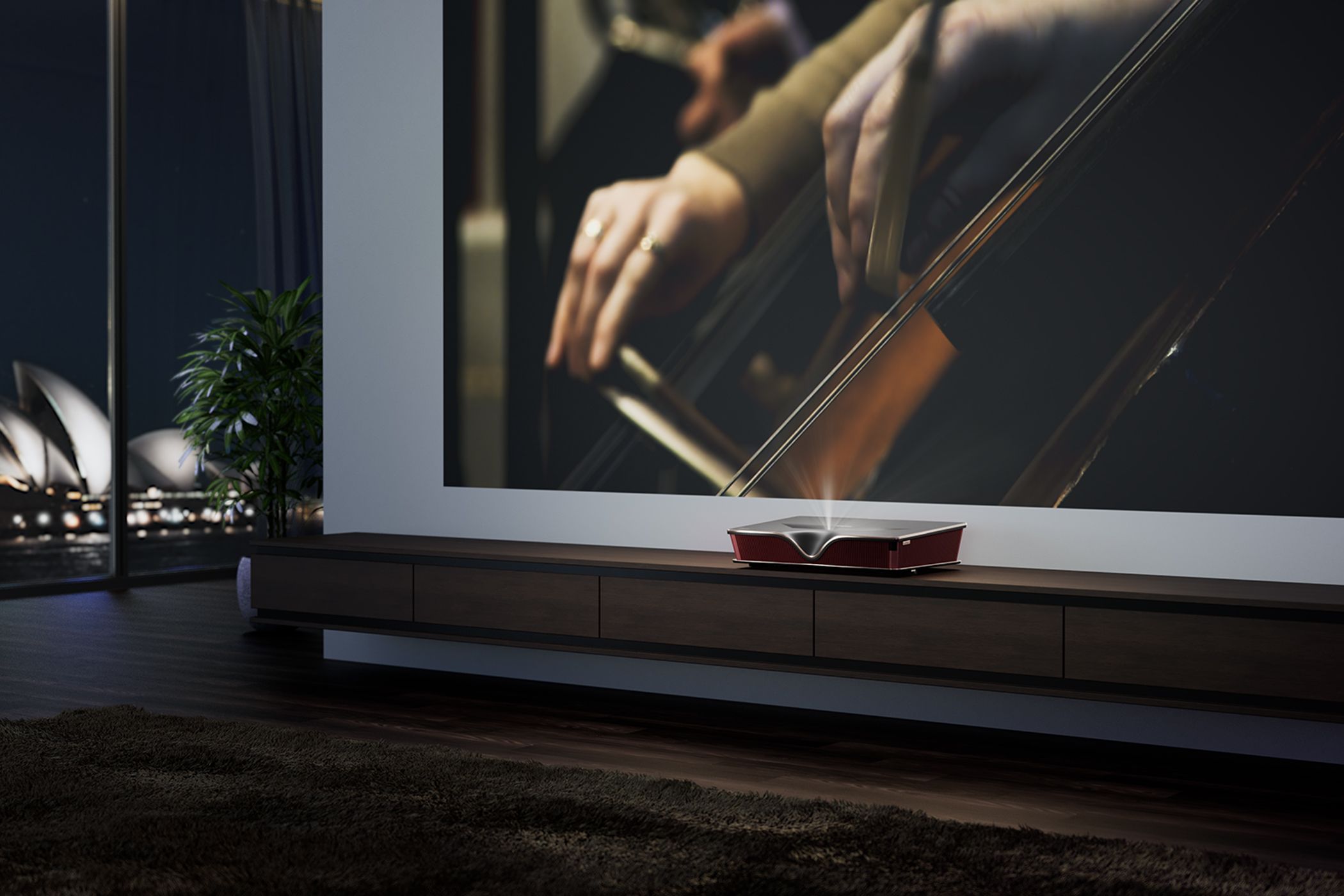 A projector TV screen shows a person playing an instrument