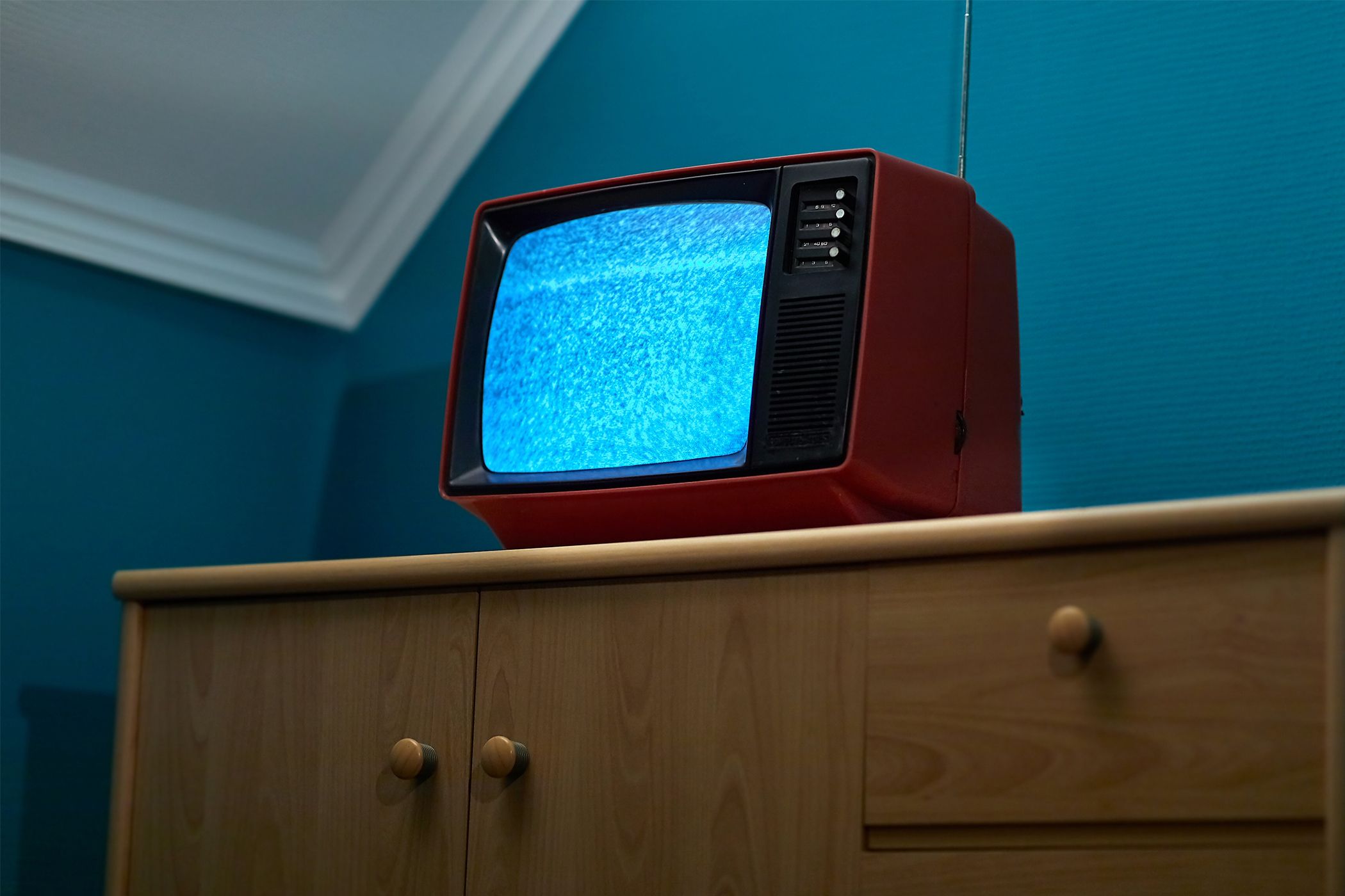 An old CRT television sitting on a dresser with a static filled screen.