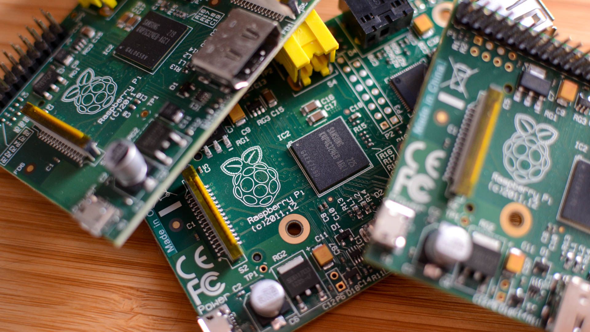 A pile of Raspberry Pis on a wooden table.