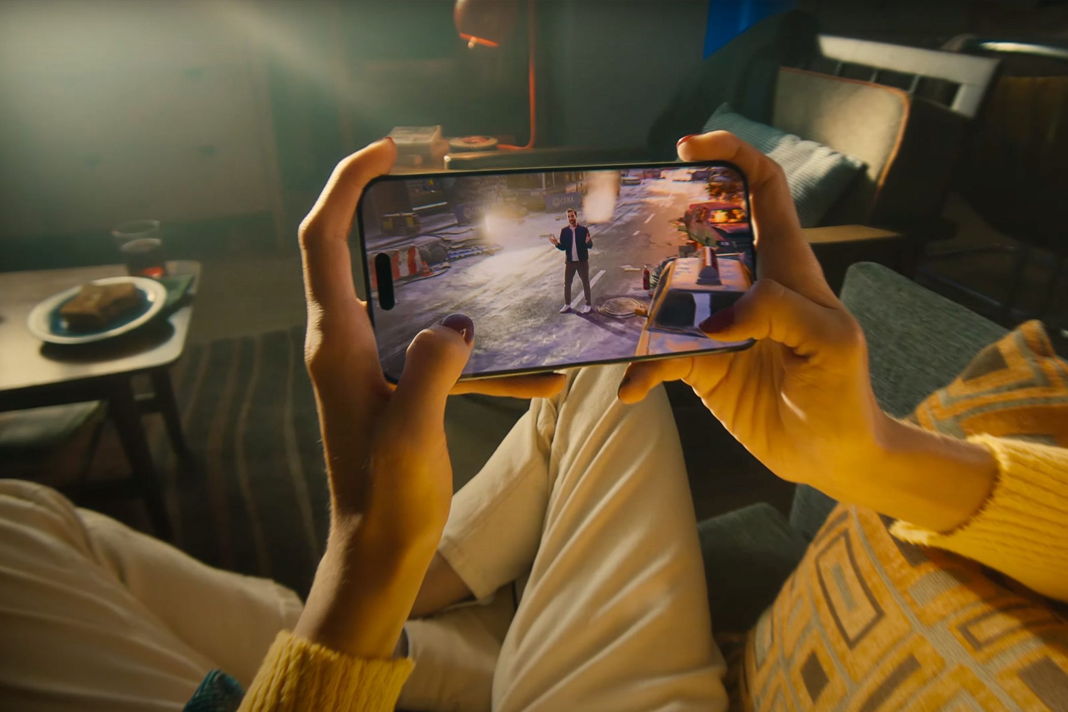 A person holding an iPhone 15 Pro, playing video games