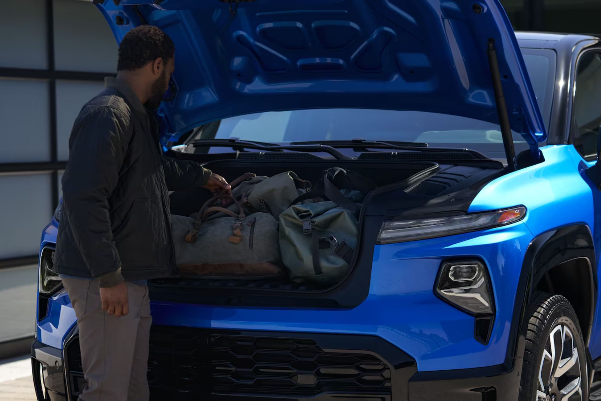 Man putting bags in the Silverado EV front trunk.