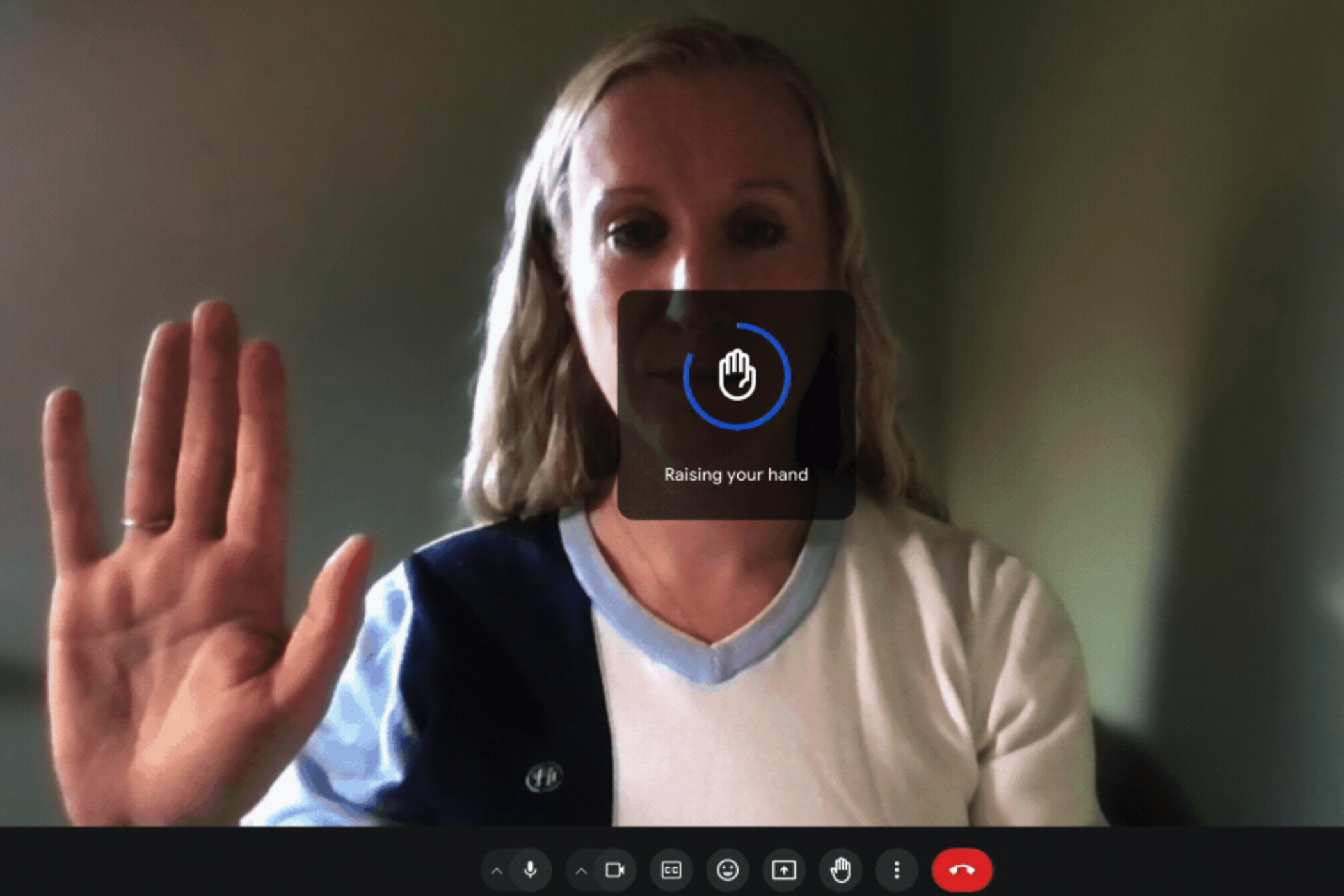 Someone using the hand-raising gesture in Google Meet. A 