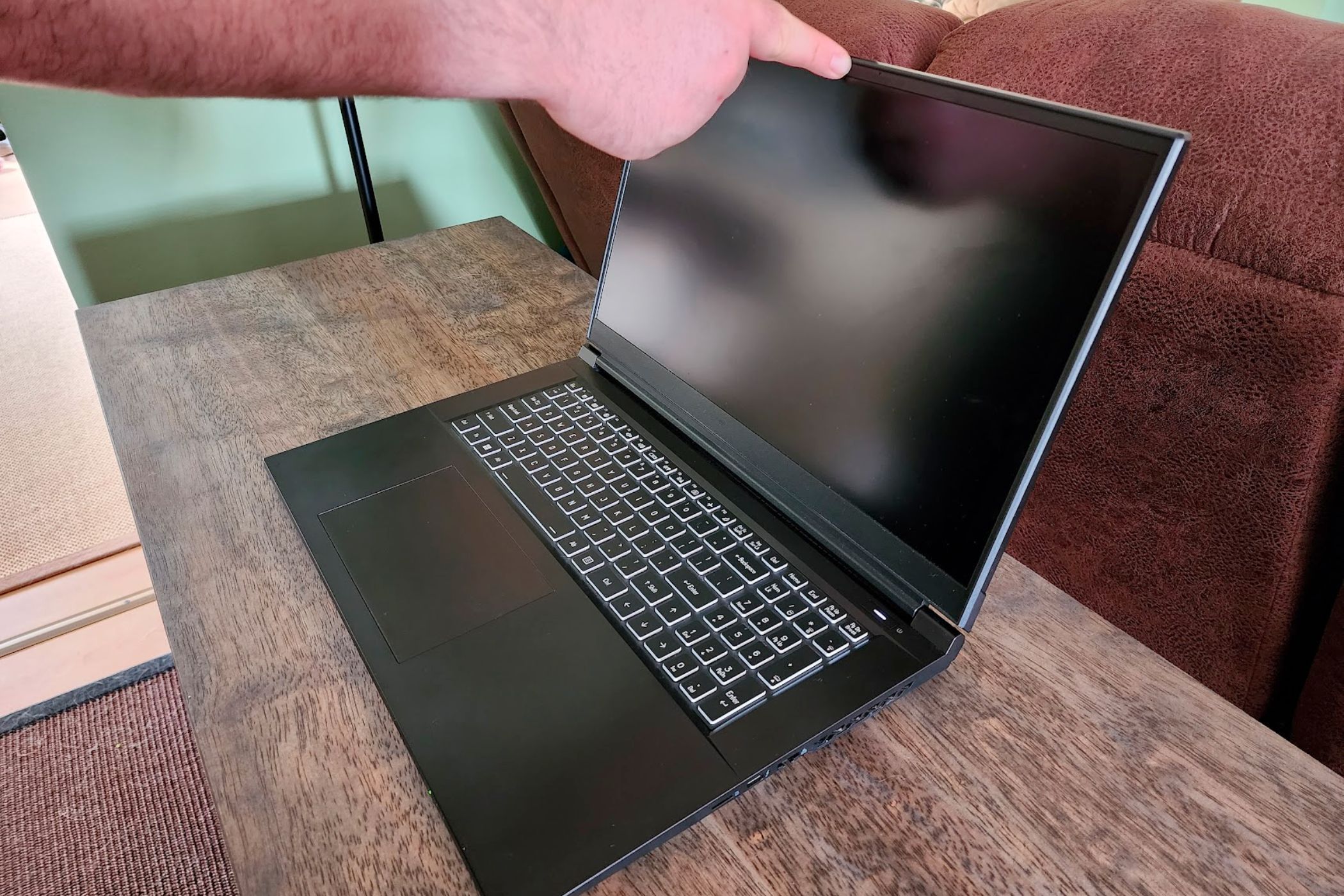 A laptop opened with one finger.