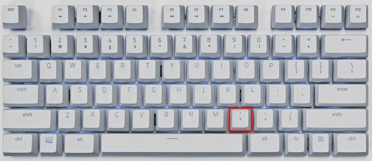 Comma key highlighted on a keyboard.