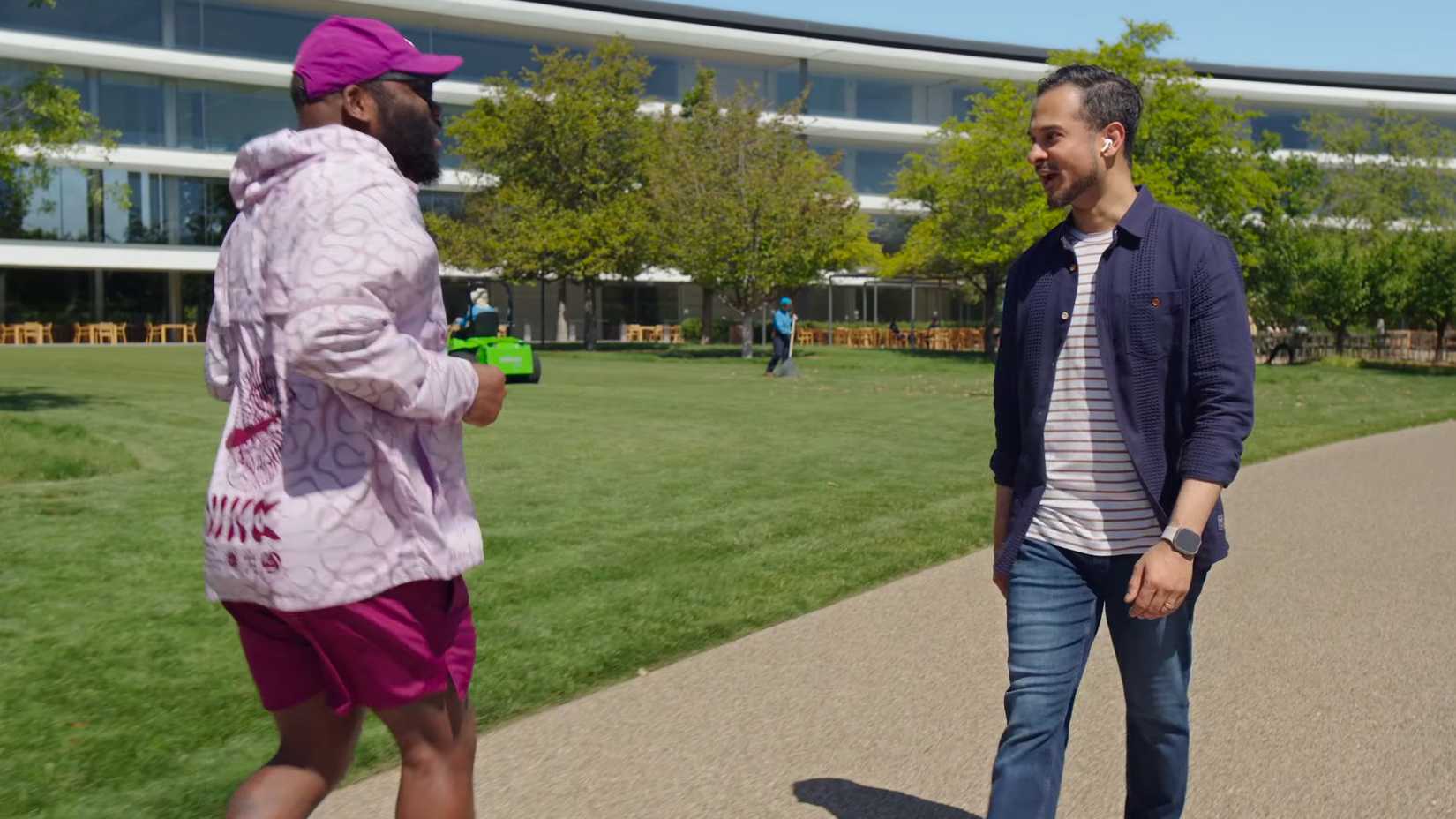 Young man conversing with a jogger in the park while wearing AirPods Pro.
