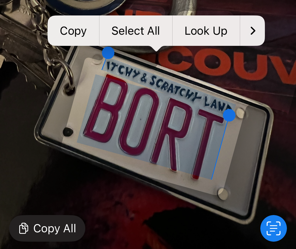 Selecting the text on a keyring using a photo in Apple Photos.