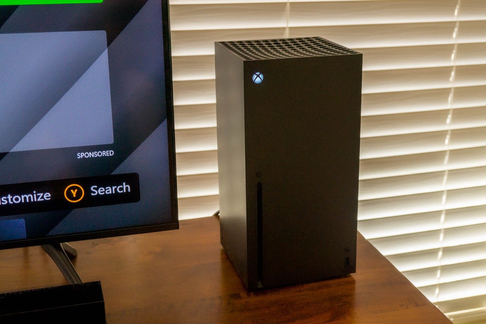 Xbox series X on a table next to a monitor