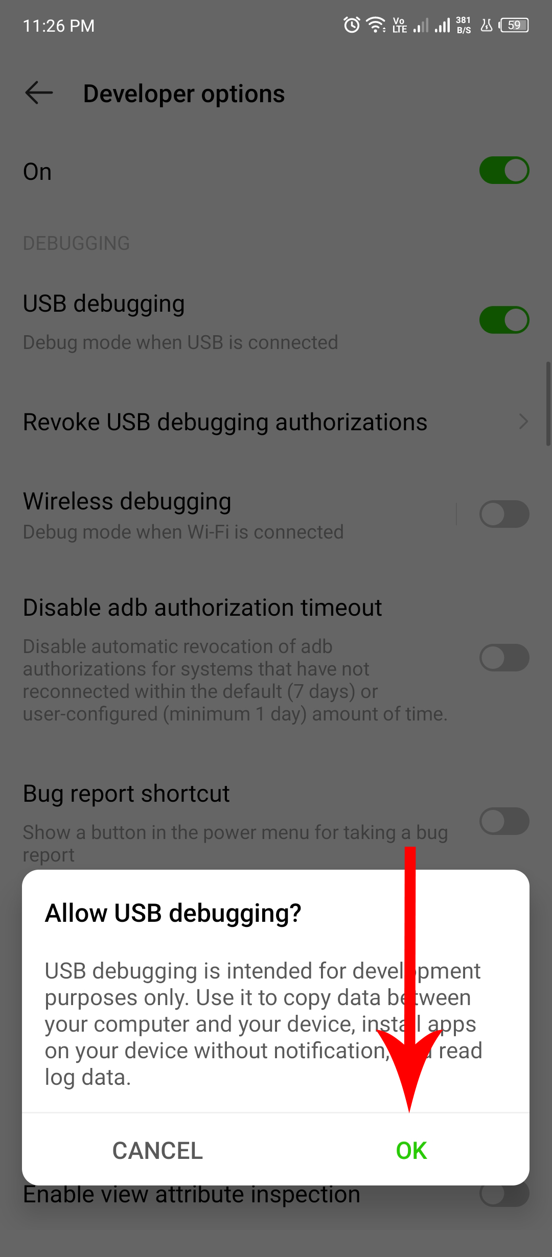 A red arrow pointing at the confirmation dialog for enabling USB debugging.