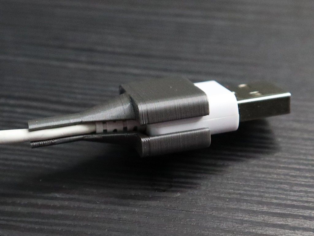 3D printed, dark gray cable saver wrapped around a white USB-A connector