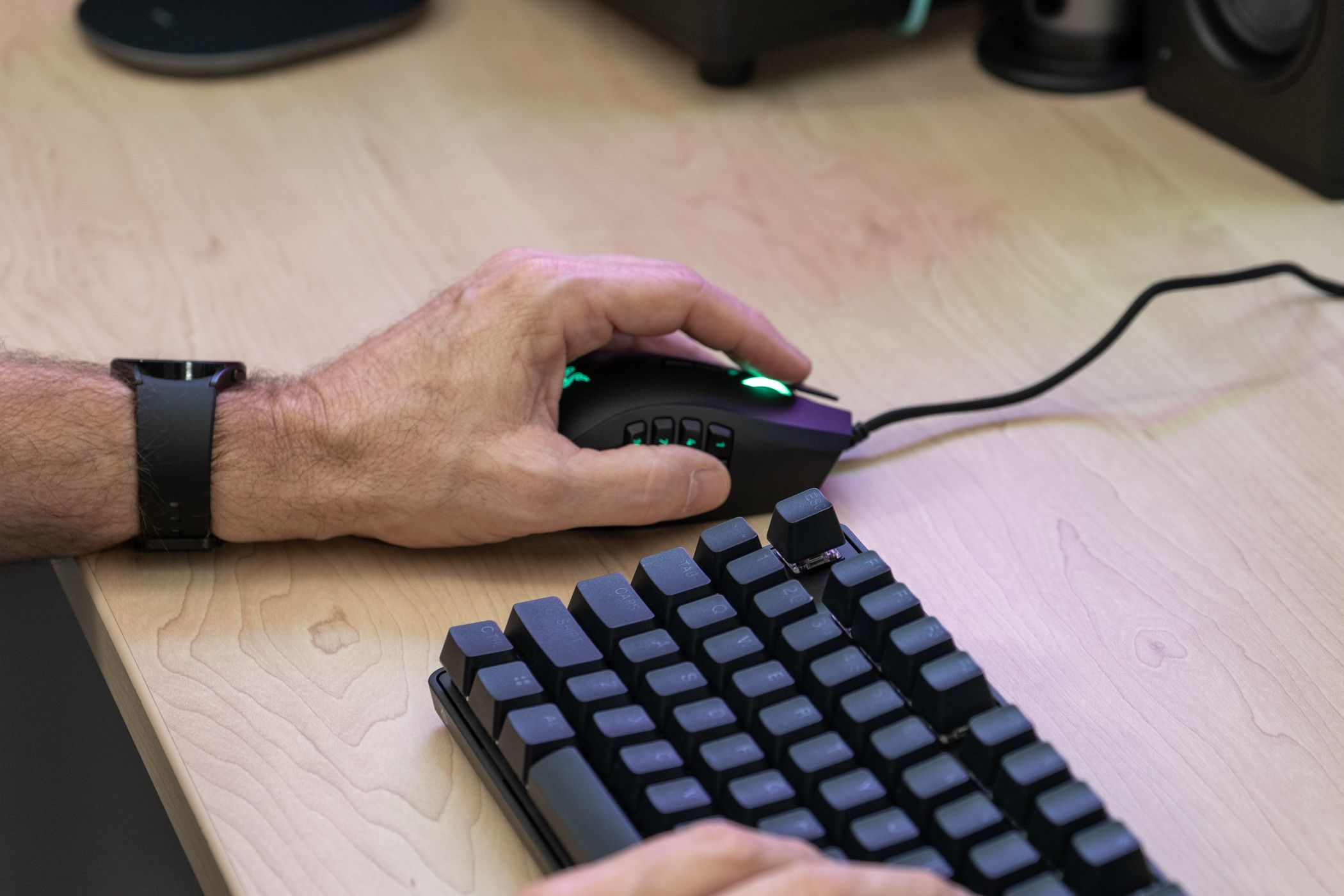 A person using a Razer mouse with their left hand. 