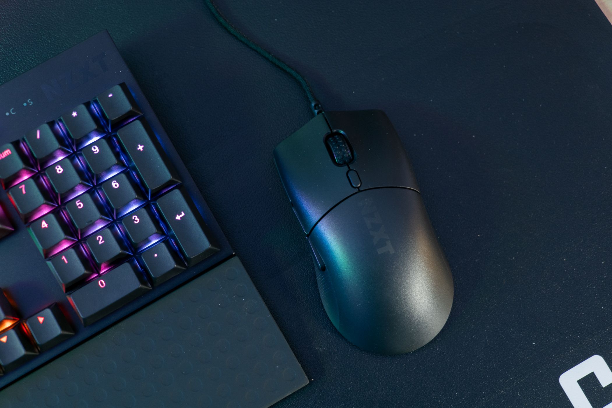 The NZXT Lift 2 Symm mouse on a desk.