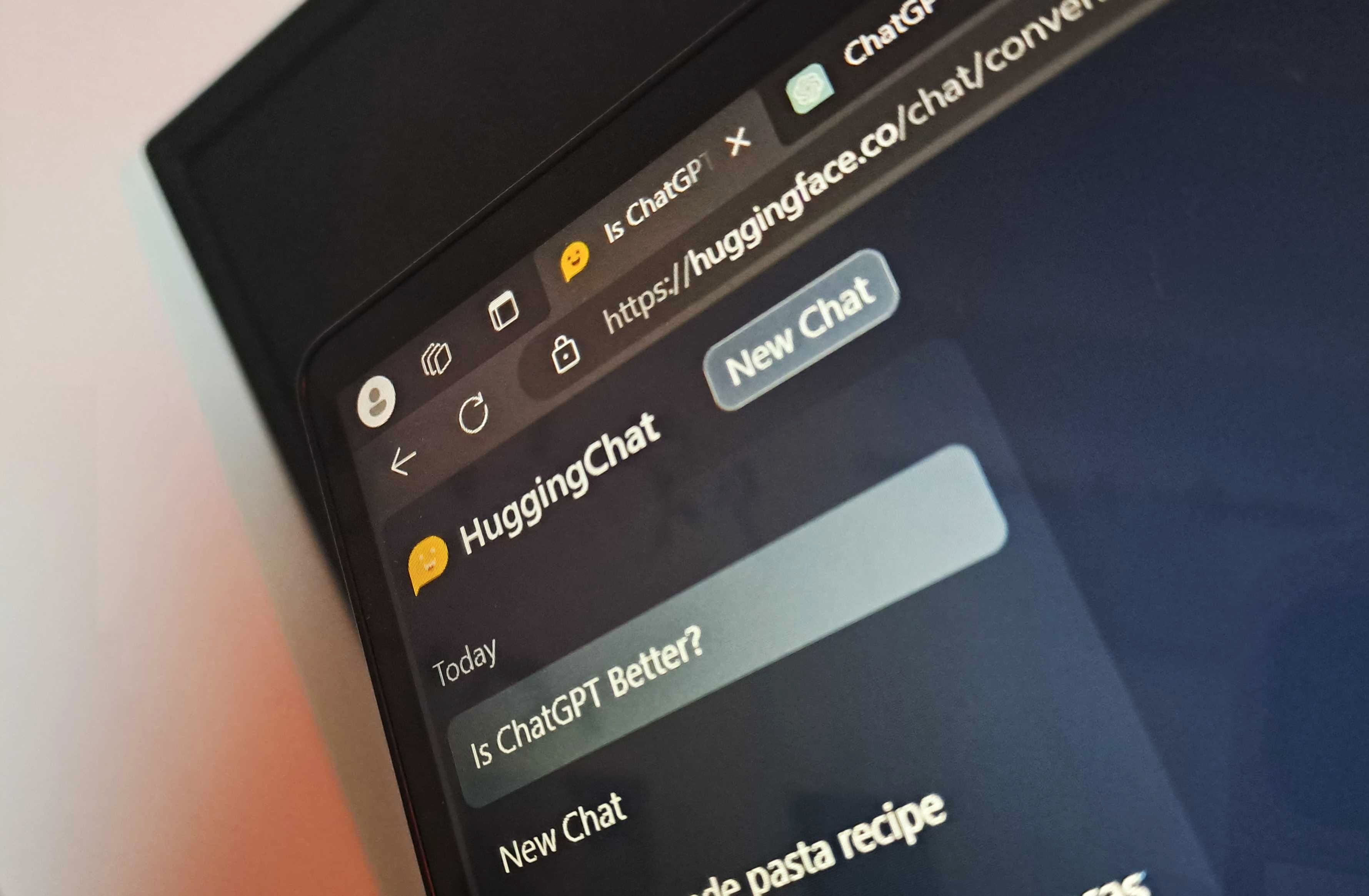 Close up photo of HuggingChat in Edge browser showing ChatGPT tab to the side.