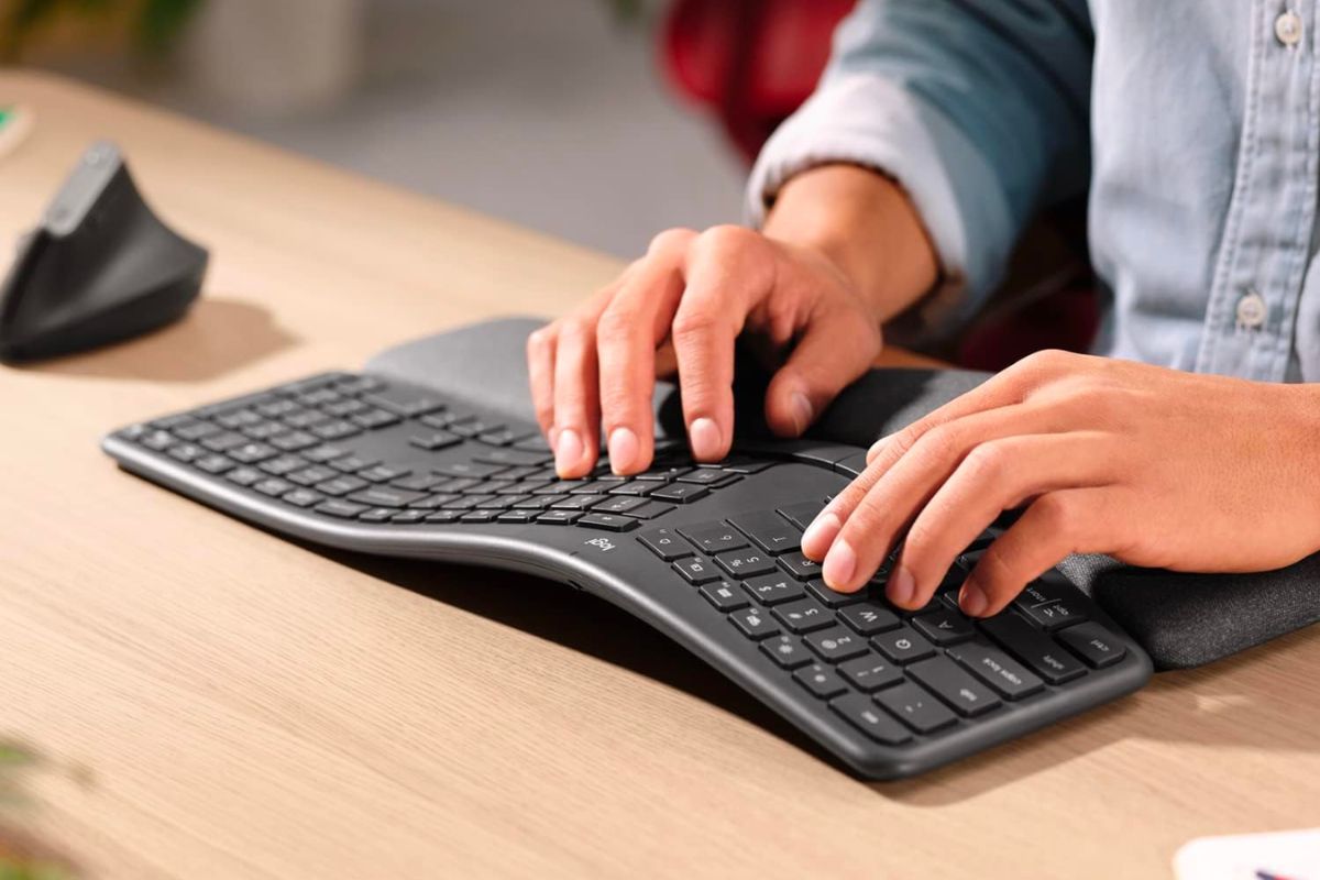 A woman's hands typing on a Logitech K860