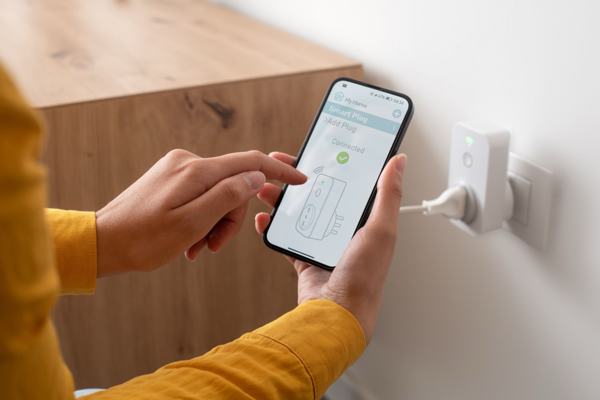 Woman setting up a smart plug at home using her smartphone.