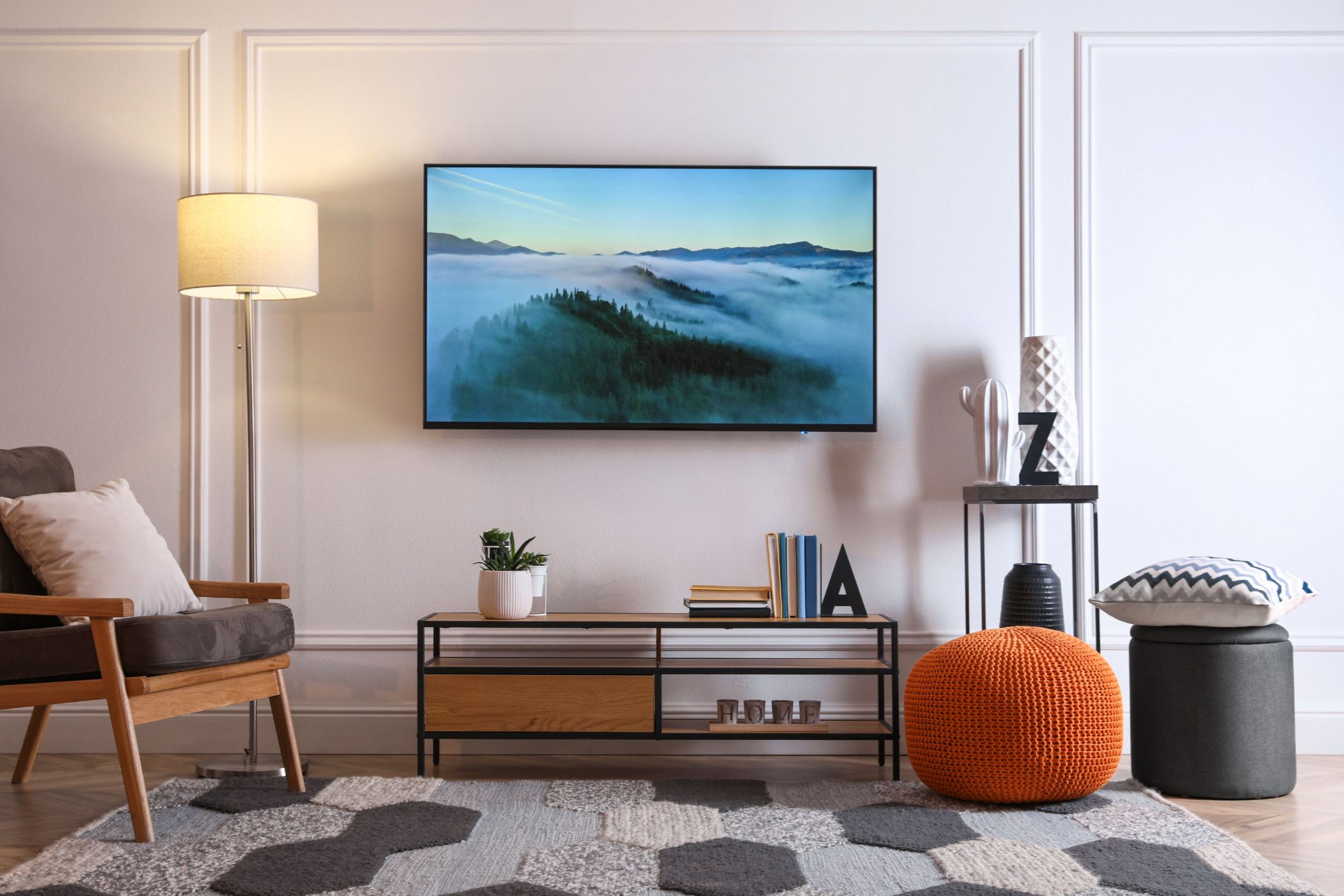 A neglected TV stand with a TV mounted too high above it.