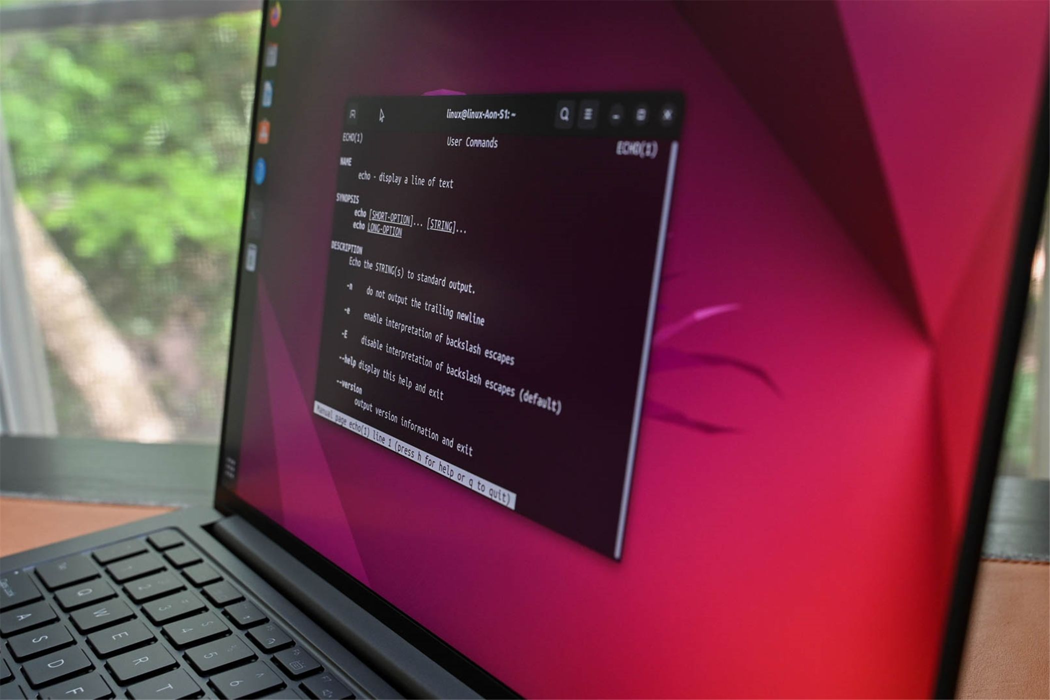A laptop running Ubuntu, showing the manual for a terminal command. 