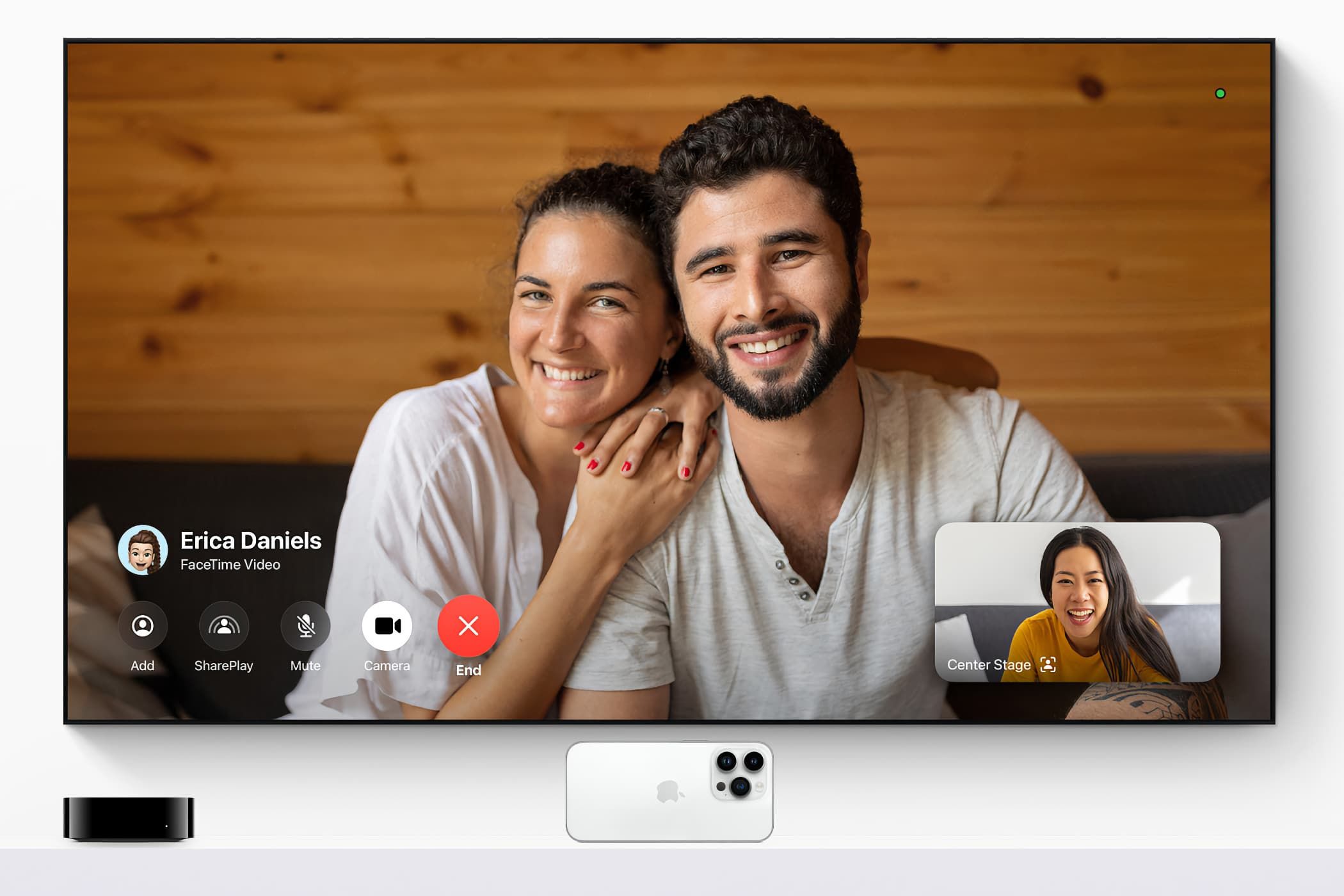 Wall-mounted TV set with Apple TV 4K and Siri Remote underneath, with the TV running FaceTime via Continuity Camera