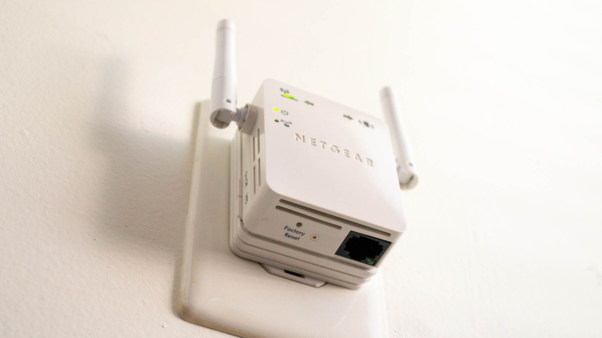 Netgear Wi-Fi extender plugged into an outlet.