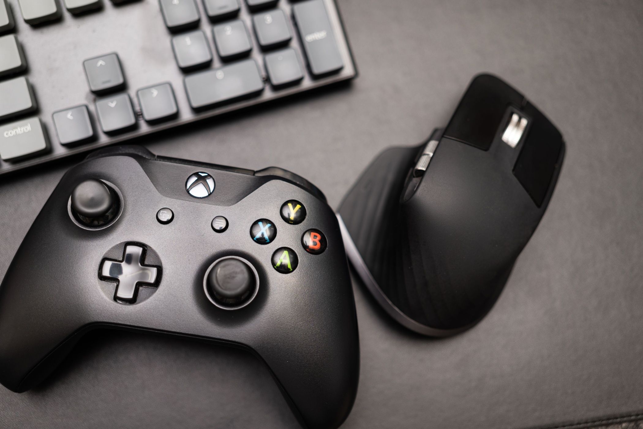 Wireless gamepad for the Xbox One on desk with keyboard. Black Xbox game controller.