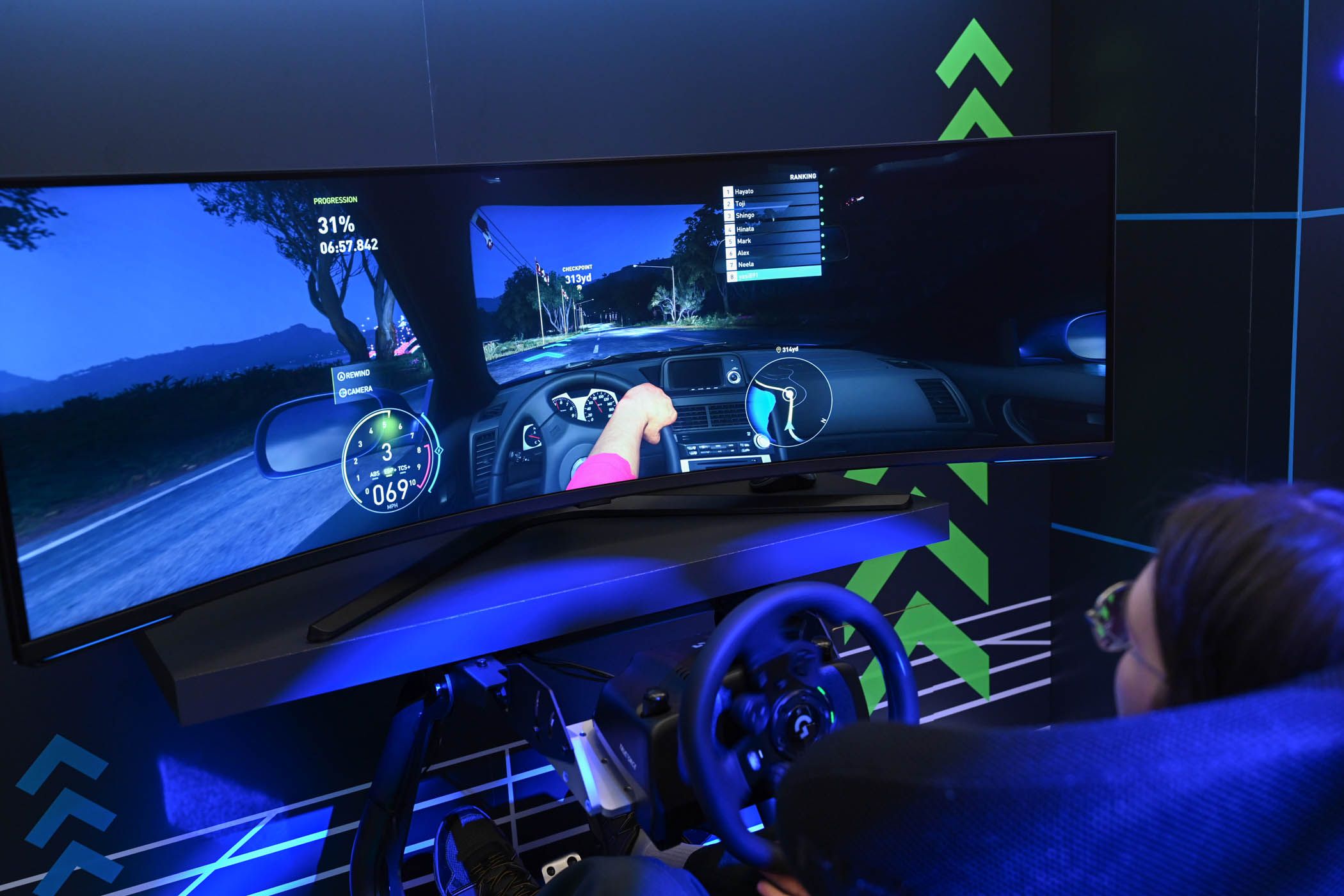 Person playing a racing game on a Samsung Odyssey curved monitor at CES 2024