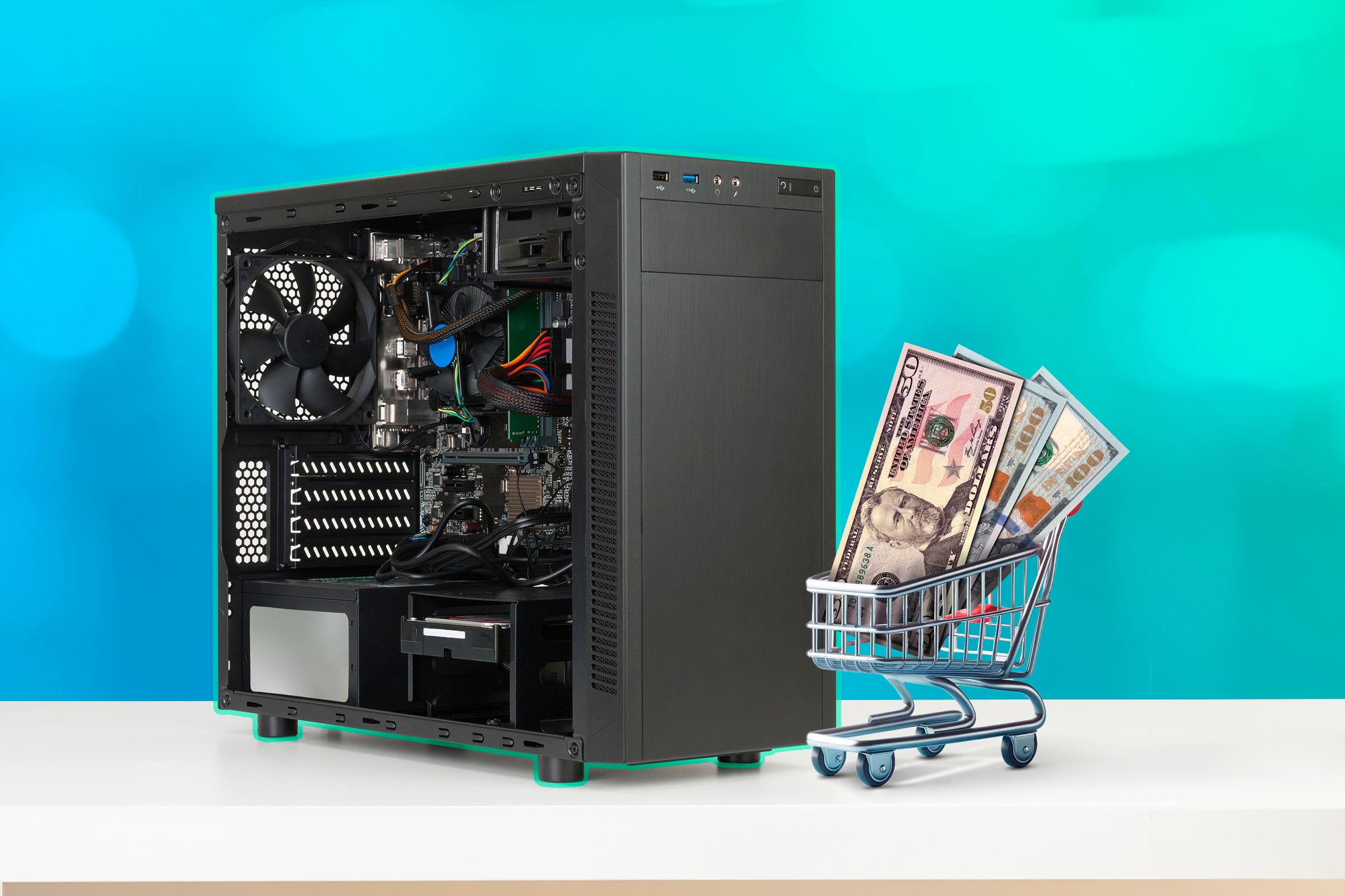 A computer case and a miniature shopping cart with some dollar bills.