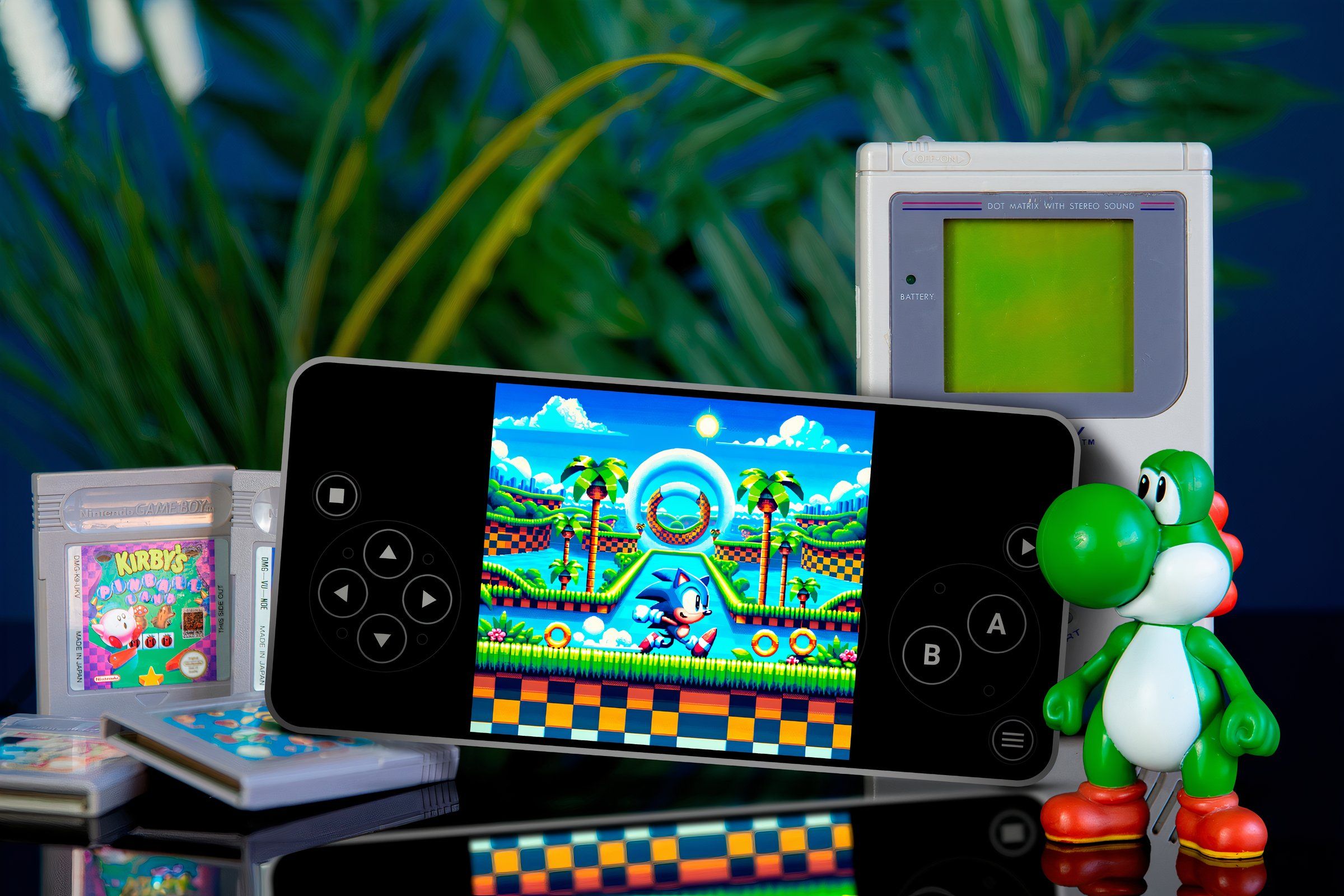 A phone running sonic game in an emulator with some cartridges around with Yoshi figure on the right and a gameboy behind.