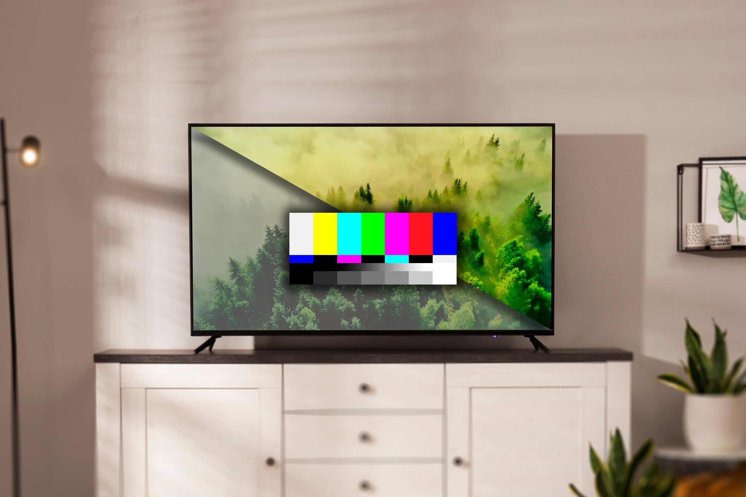 A TV on a shelf with a split screen showing an image with muted colors on the left and more balanced colors on the right, and a test color bars image in the center of the screen.