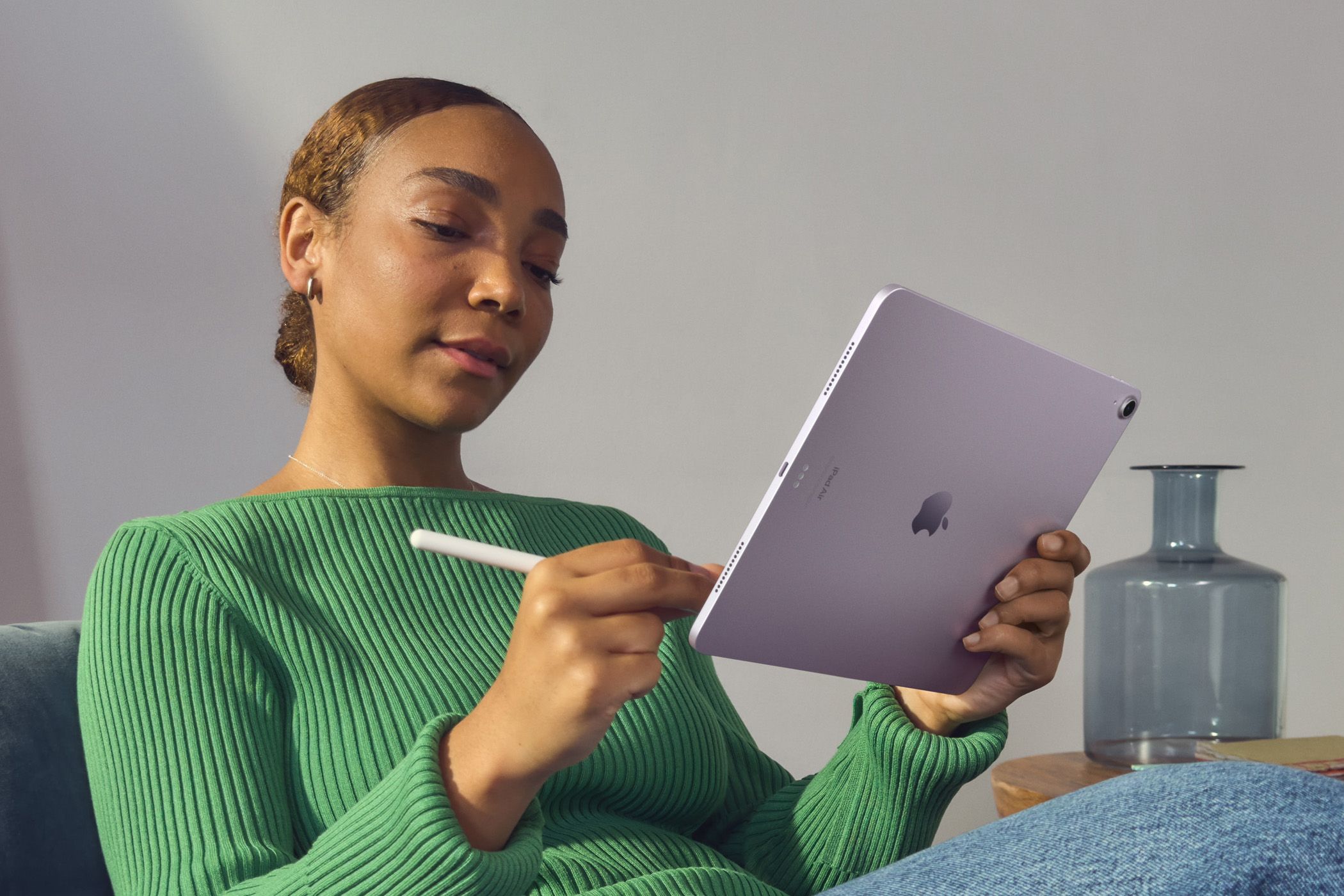 Person in green sweater using an iPad with the Apple Pencil.