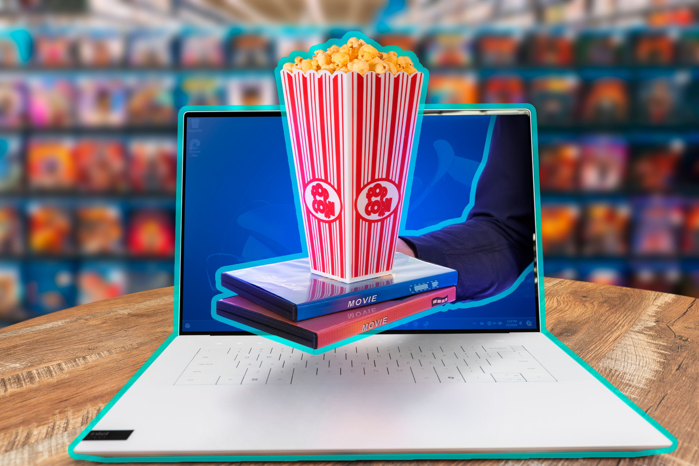 One holding some movies and popcorn coming out of a laptop.
