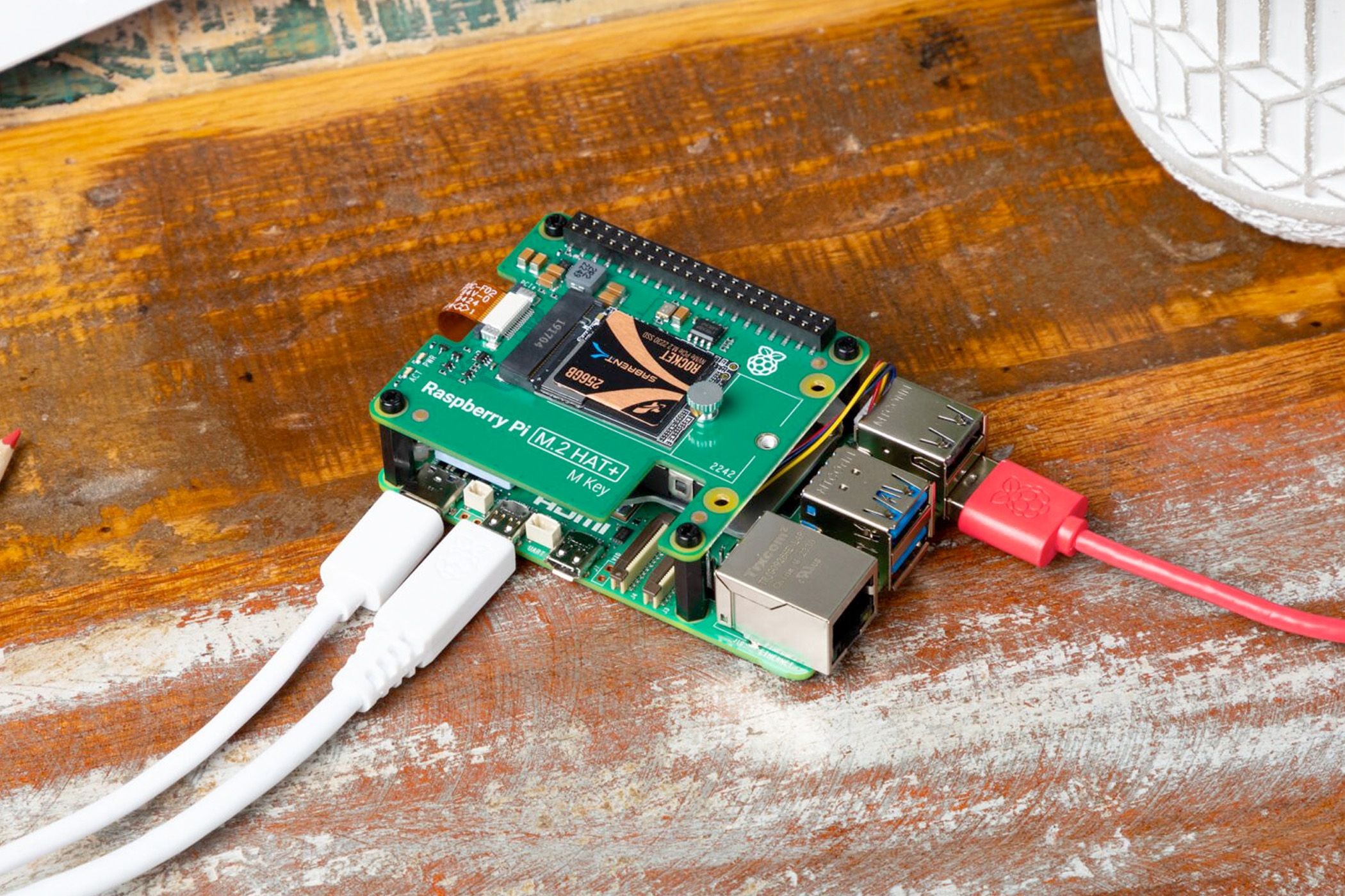 Raspberry Pi computer on a wooden surface with cables connected.