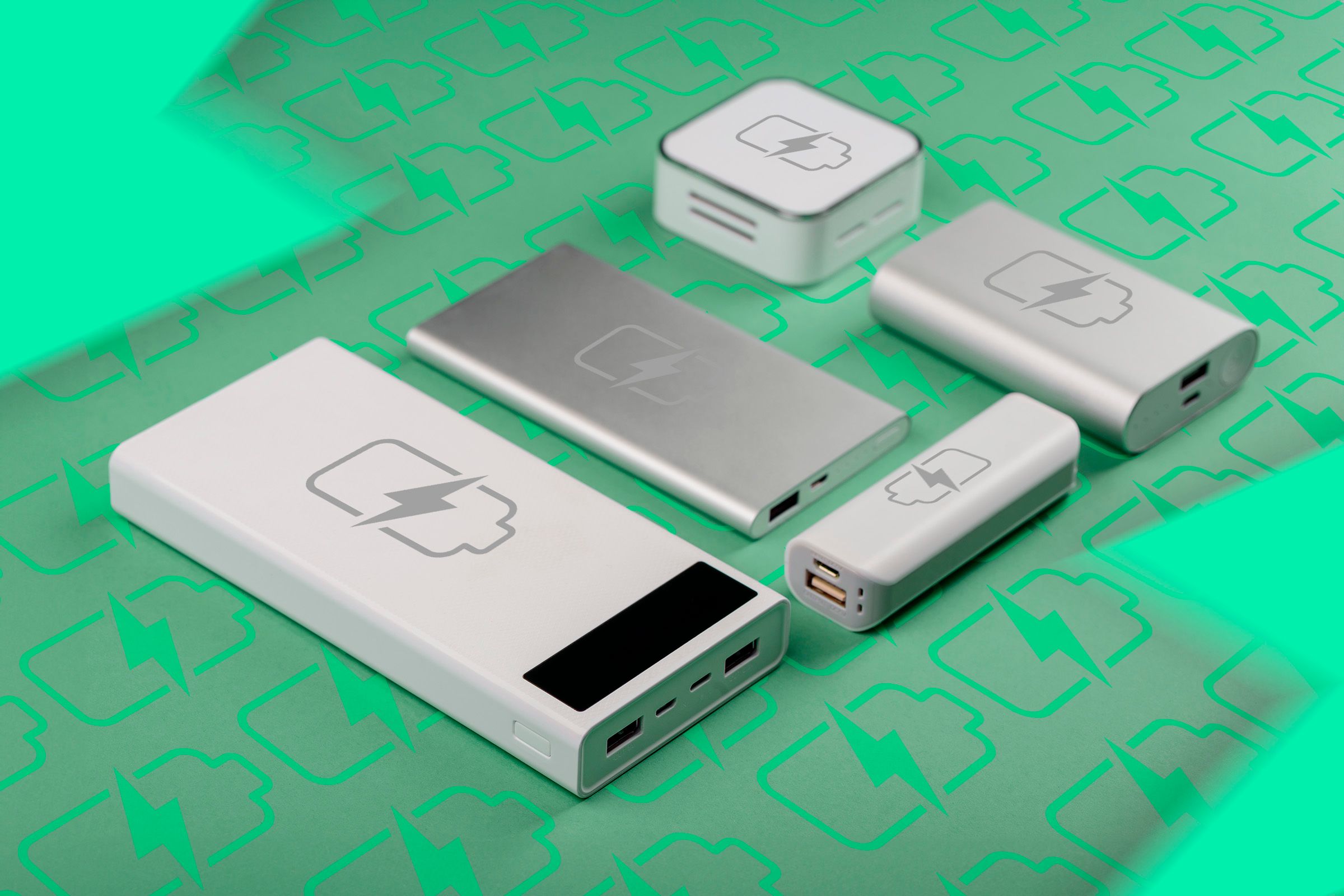 Power banks on a green background with a lot of battery charging icons.
