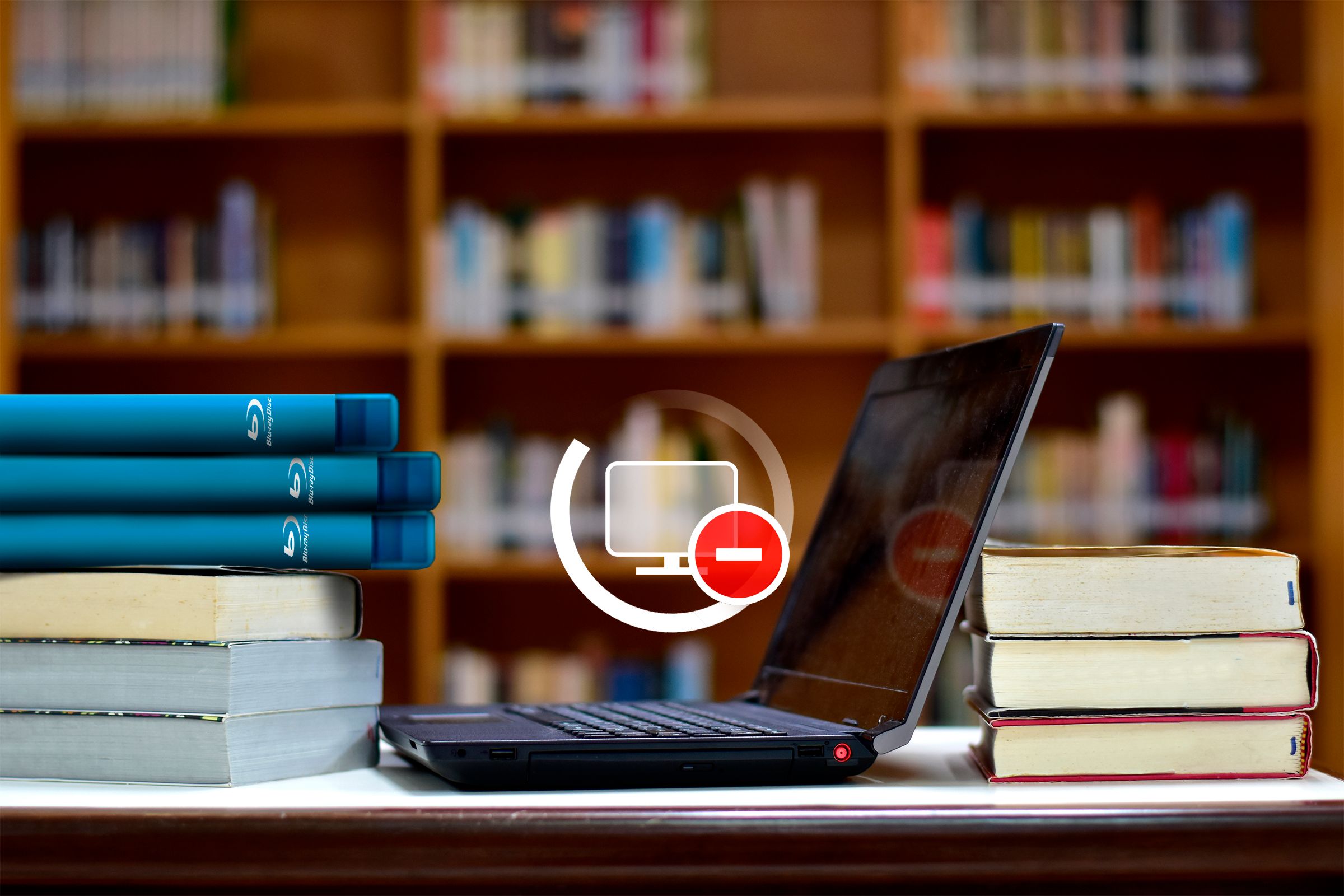 Stack of books and some blu-rays with a laptop on a table and a 'no internet' icon.