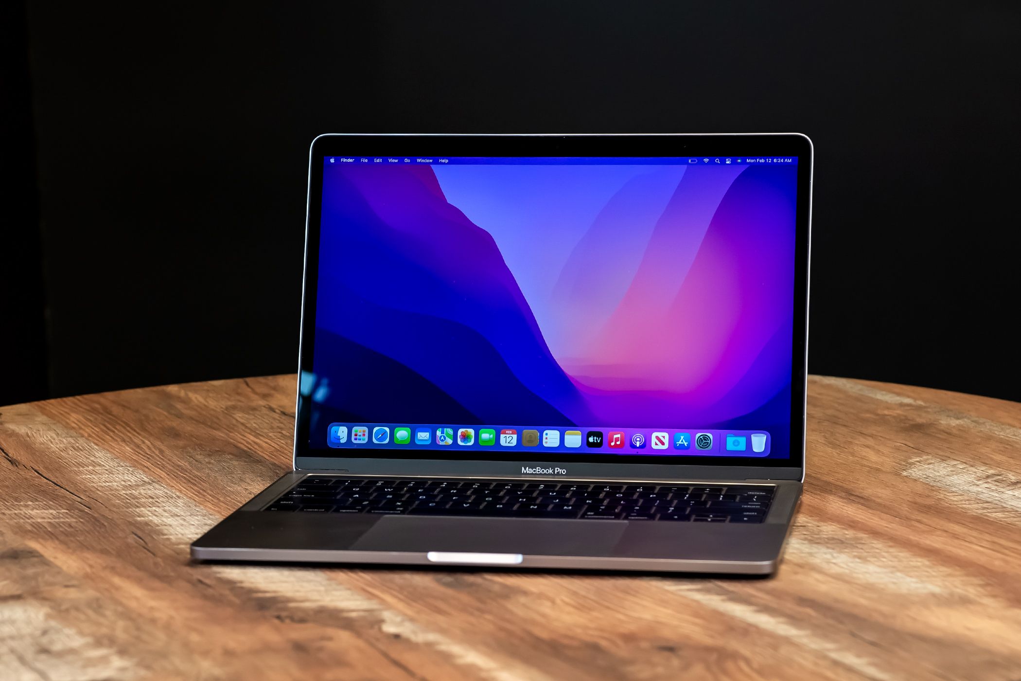 A MacBook Pro on a table, open and powered on.