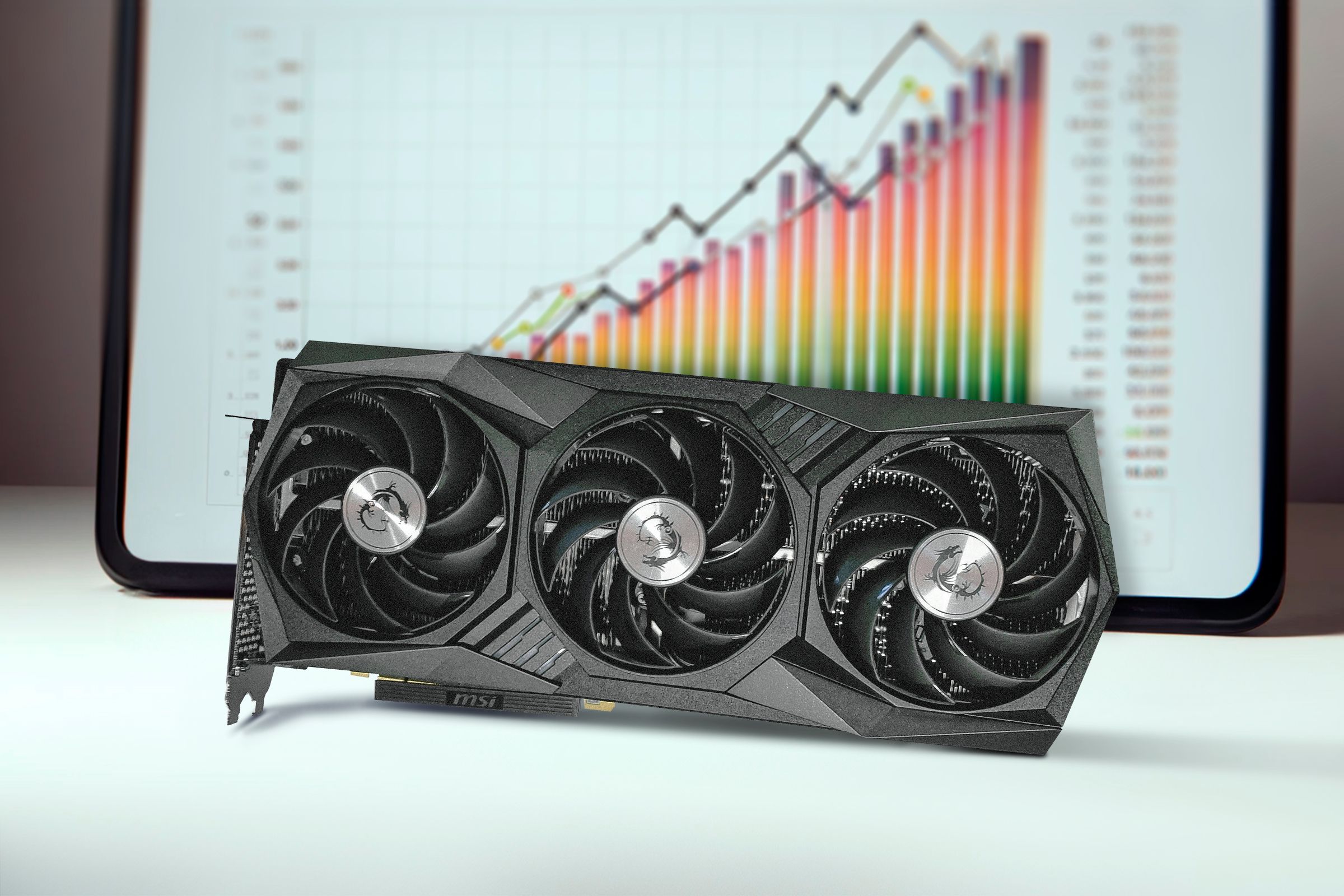 A GPU and a benchmark chart in the background.