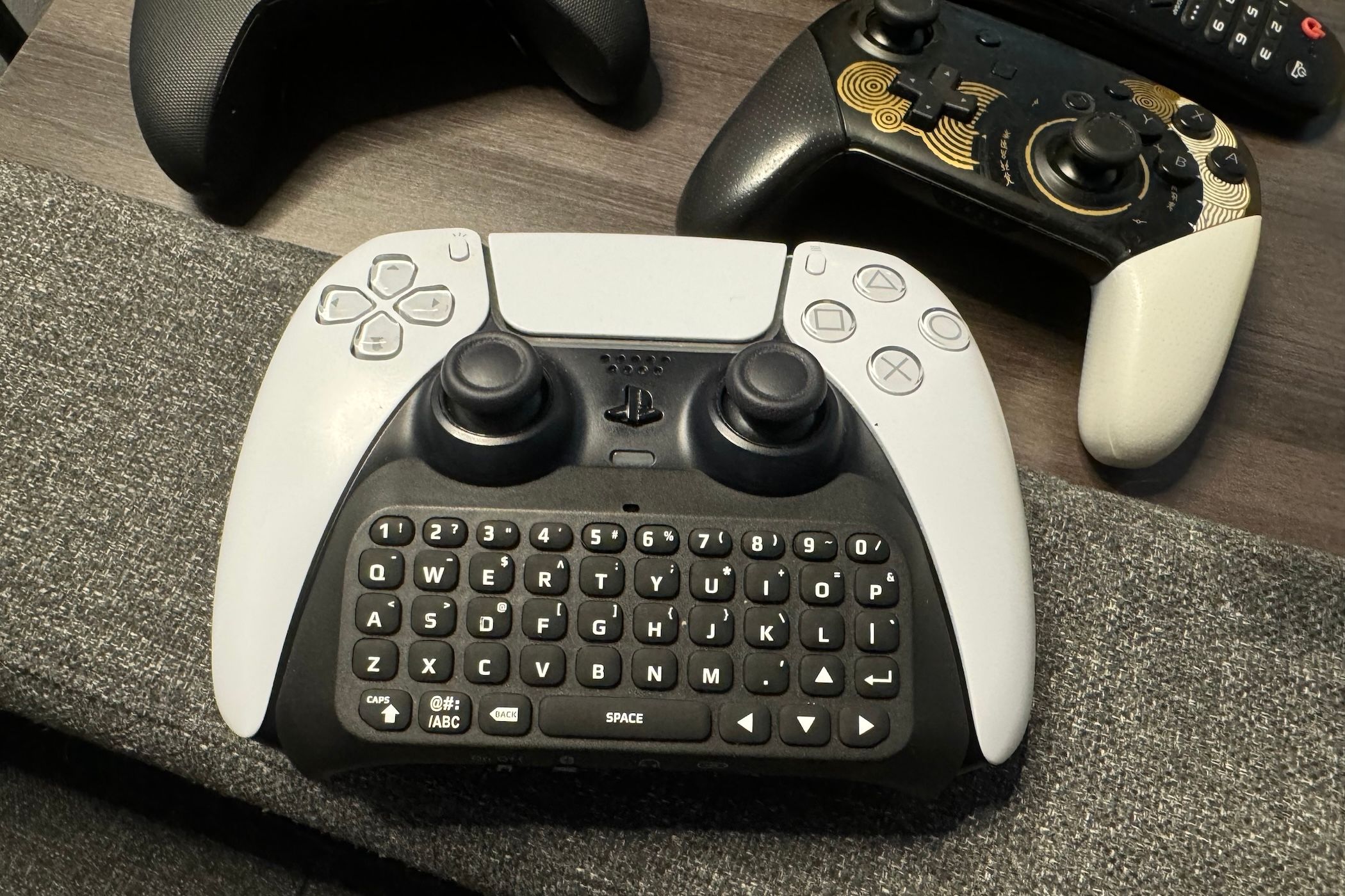 A PlayStation 5 DualSense controller with mini keypad connected.