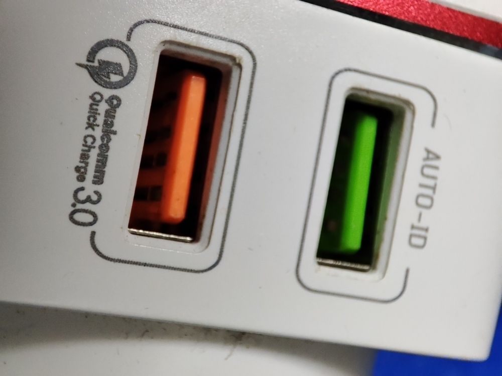 White and red USB charger adapter. There are two green and red USB ports.
