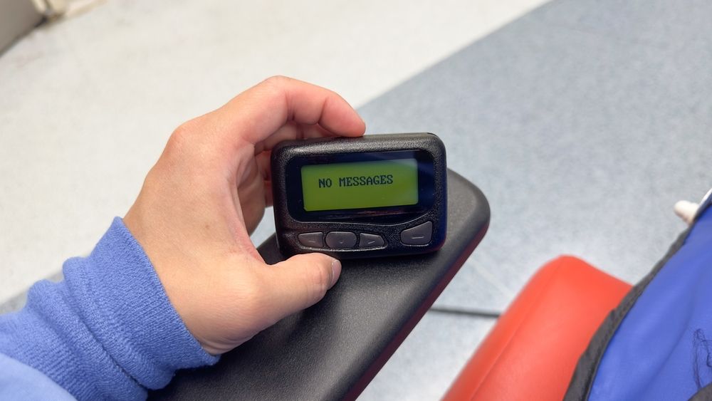 shutterstock_2314723997A beeper held in someone's hand, seen from their perspective. The screen shows there are no messages.