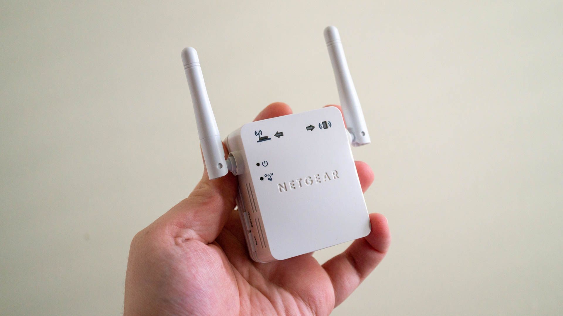 Person holding a Netgear Wi-Fi extender.