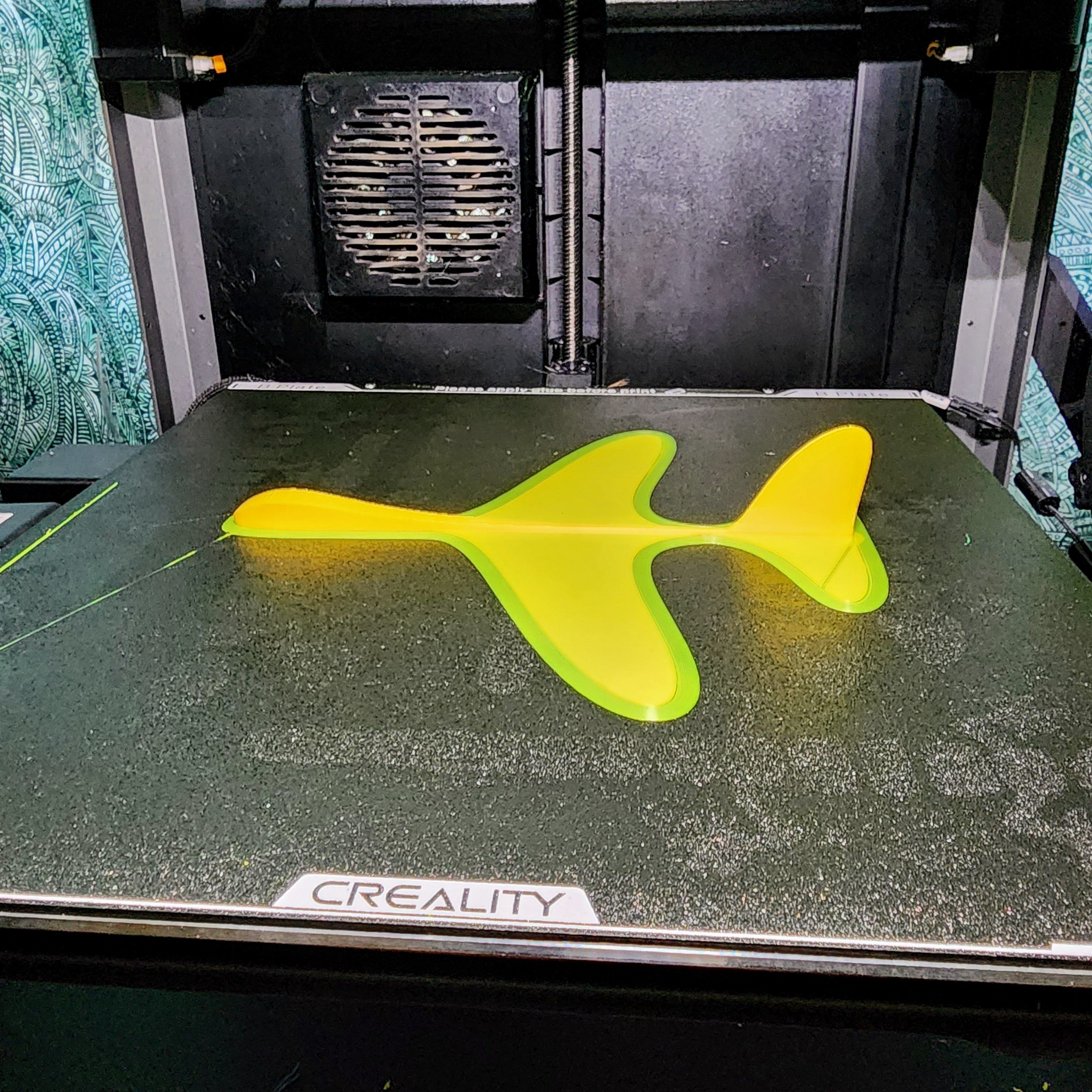 A yellow 3D printed glider inside a 3D Printer.
