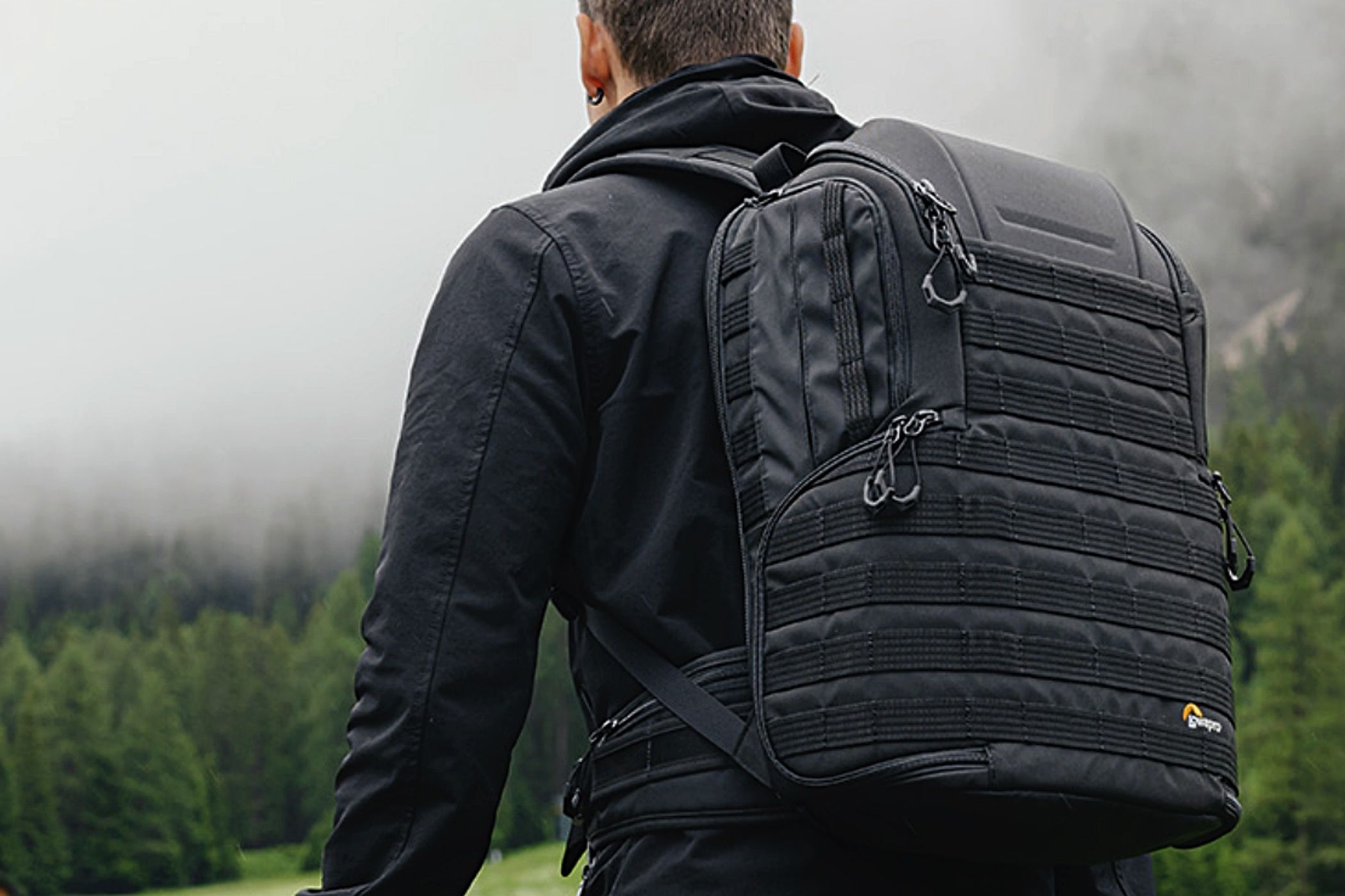 A man hiking with a Lowepro ProTactic BP 450 AW II on his back.