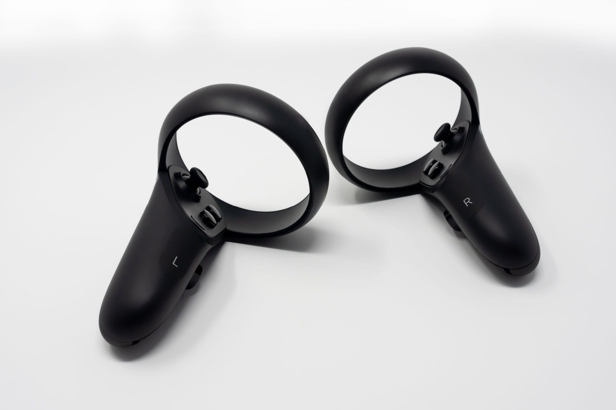 Black motion controllers with triggers, buttons, analog sticks and touch.