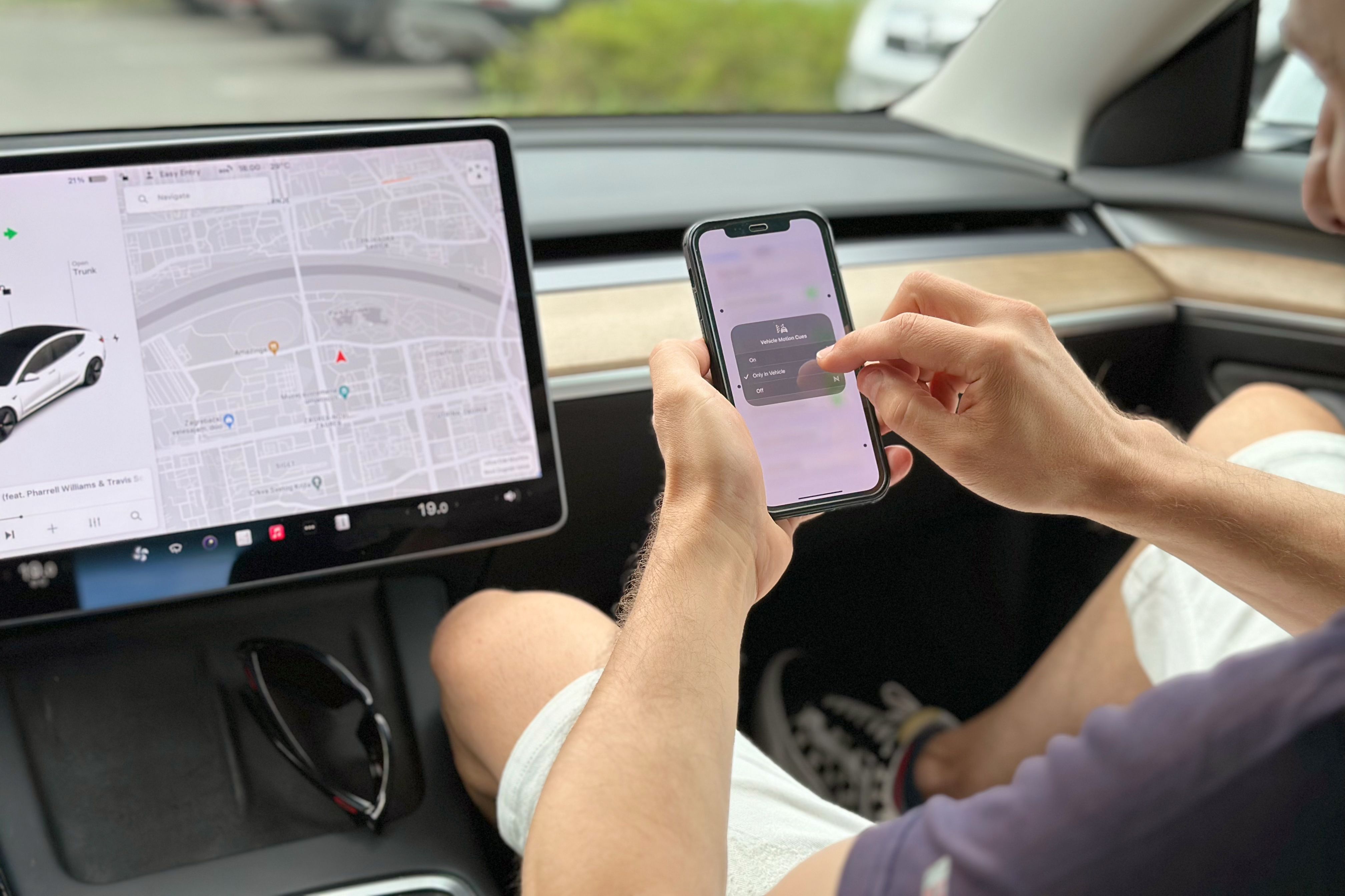 A Tesla passenger enabling Vehicle Motion Cues in their iPhone's Control Center.