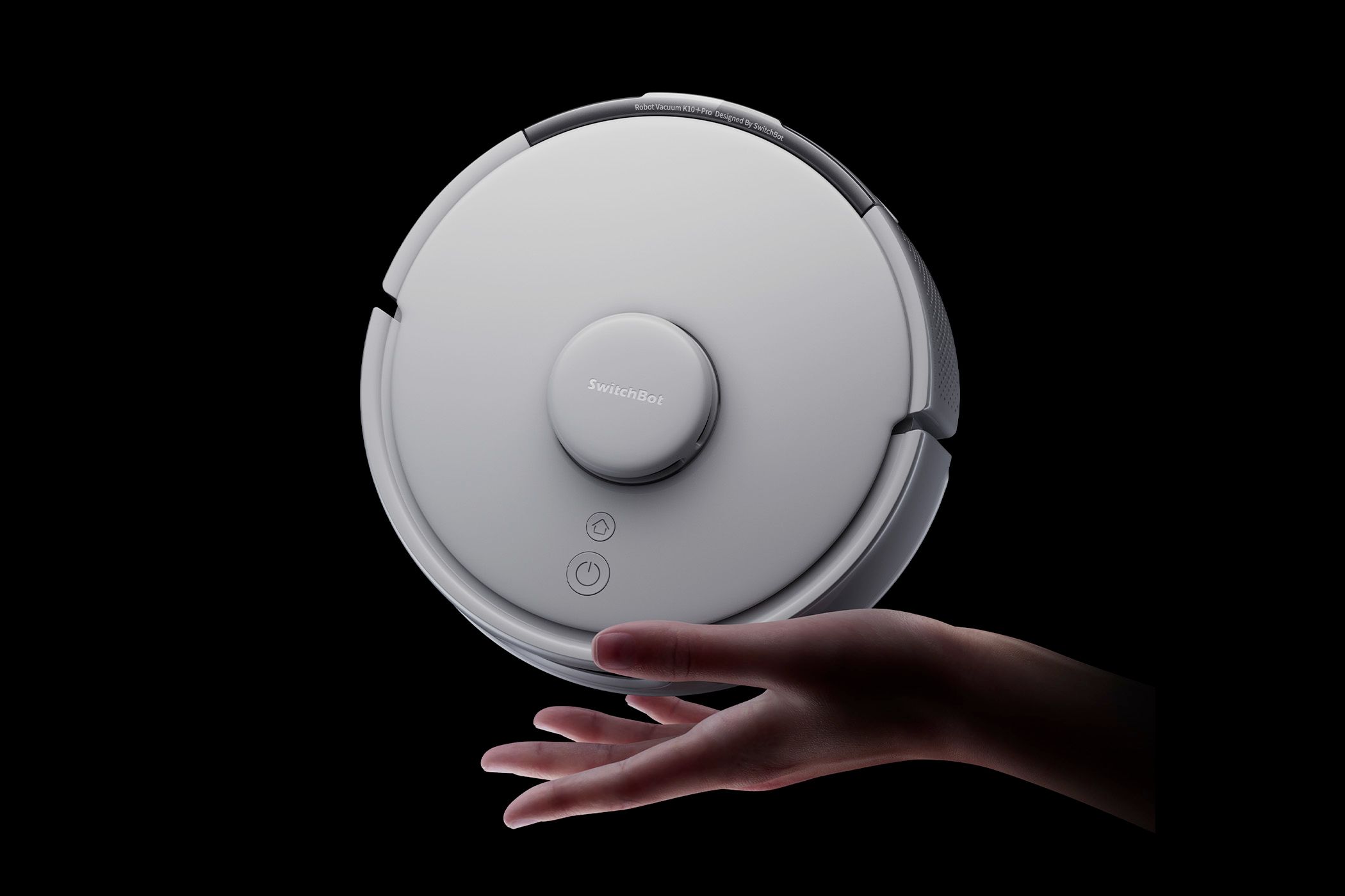 A hand holding the SwitchBot Mini K10+ Pro robotic vacuum.