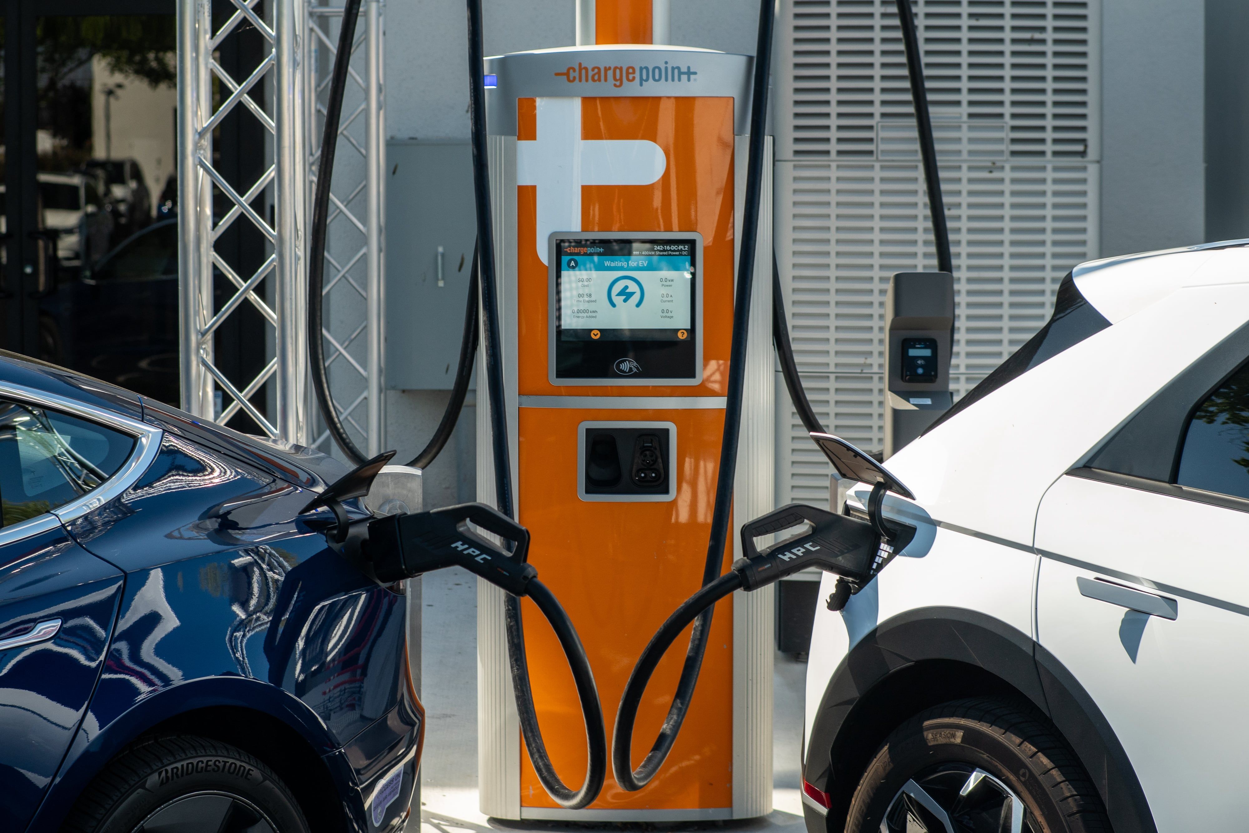 Two electric vehicles being charged at a ChargePoint charging station.