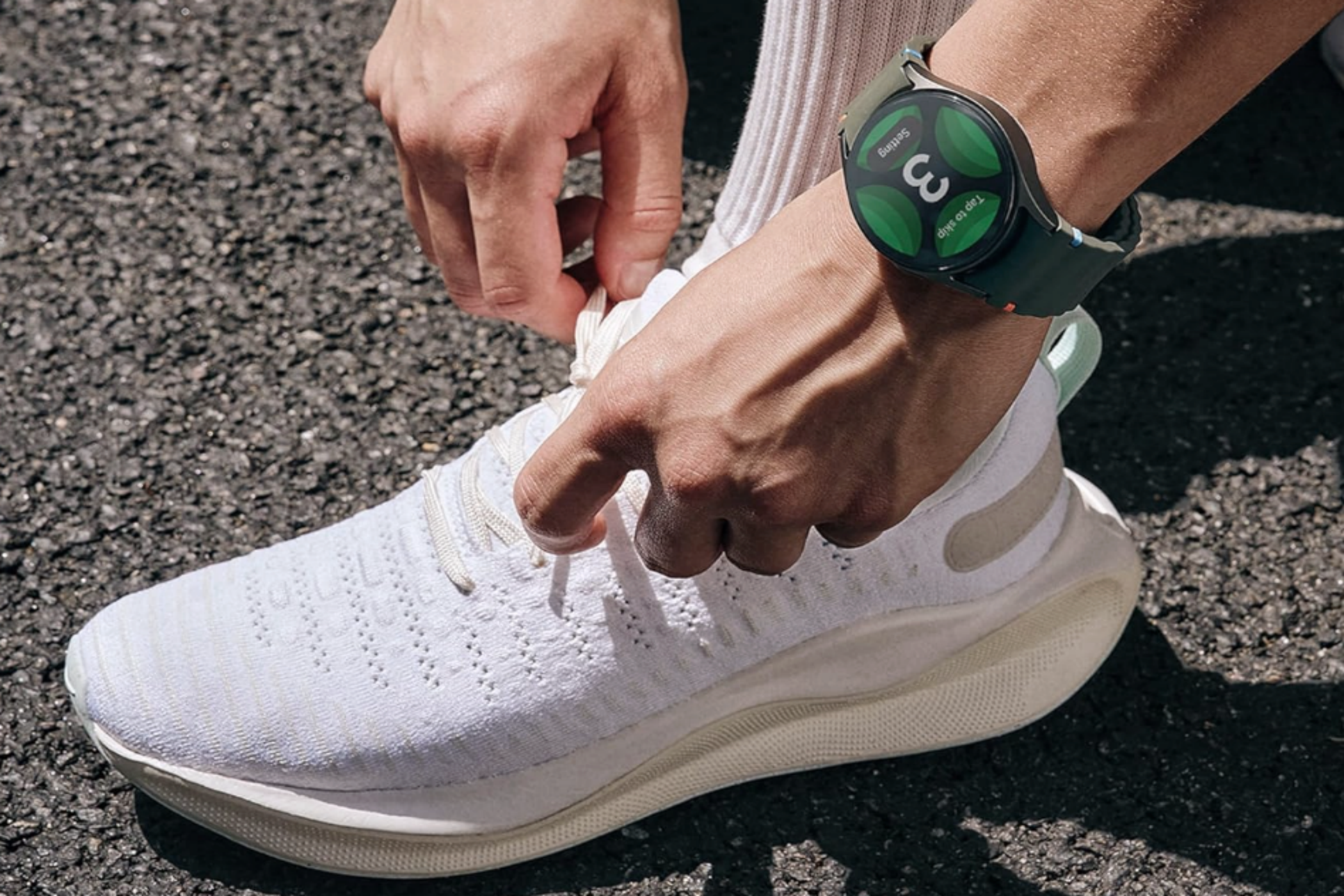 A man tying his shoelaces while wearing a Samsung Galaxy Watch7.