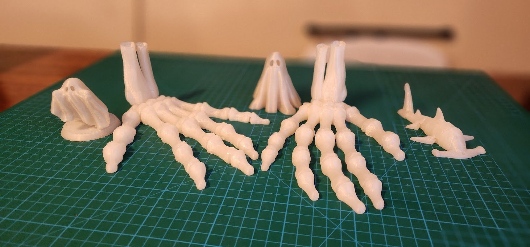 Glow in the dark 3D prints of skeletal hands and ghost, plus one hammerhead shark.